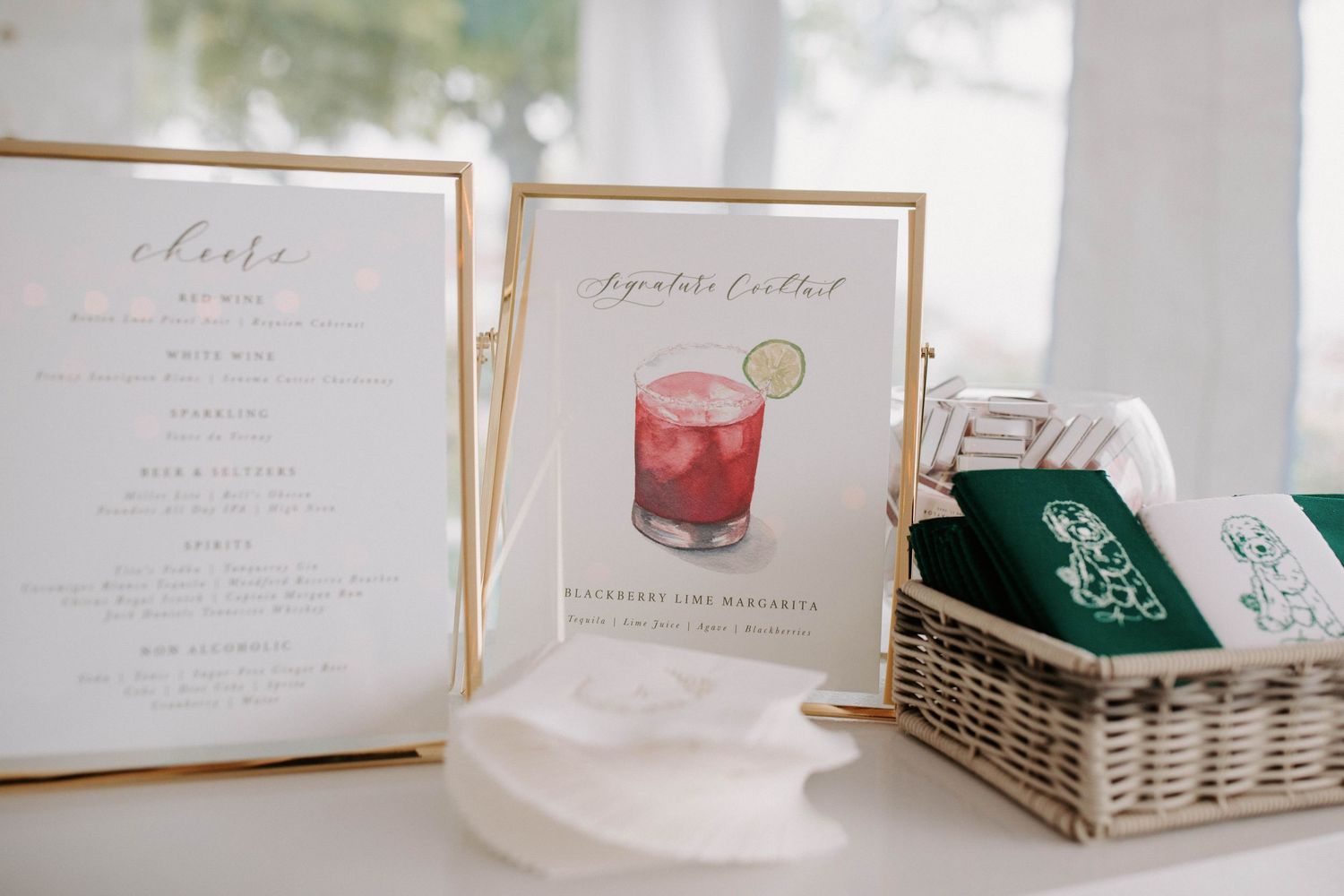 Elegant wedding invitation suite with gold frames and white paper displayed on a textured surface.