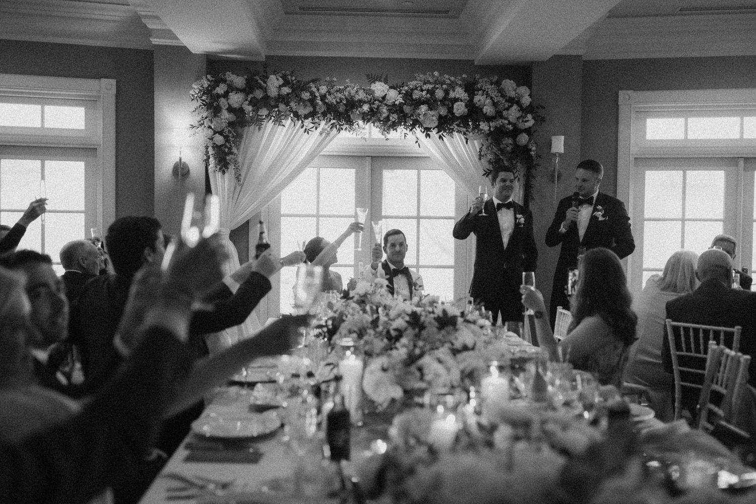 Wedding celebration panorama showing decorated tables and guests in an elegant venue.