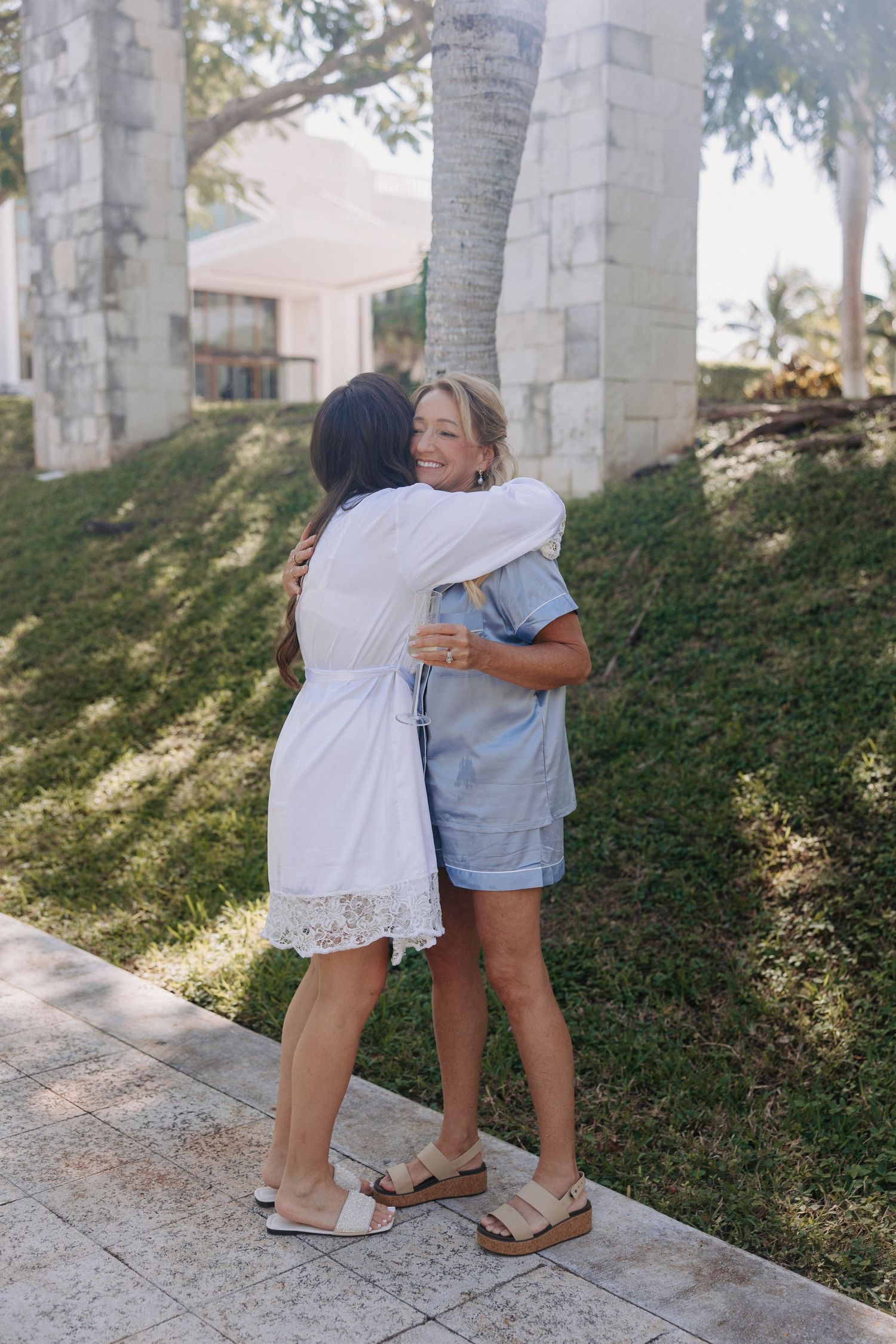 Candid moments captured between friends in matching outfits near white pillars.