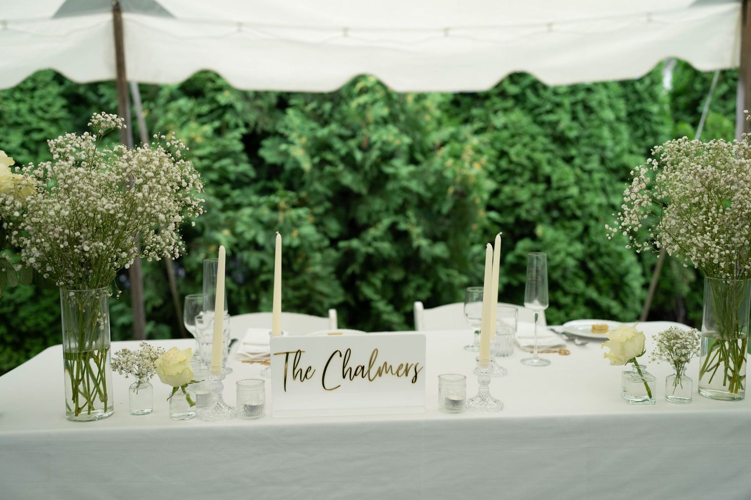 Wedding reception tables decorated with white flowers and name cards overlooking a waterfront.
