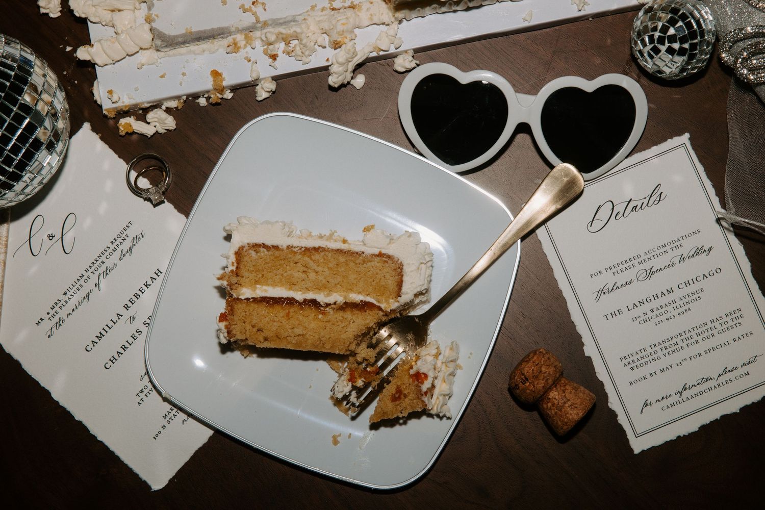 Heart-shaped plates with dessert remnants and place cards on a dark table.