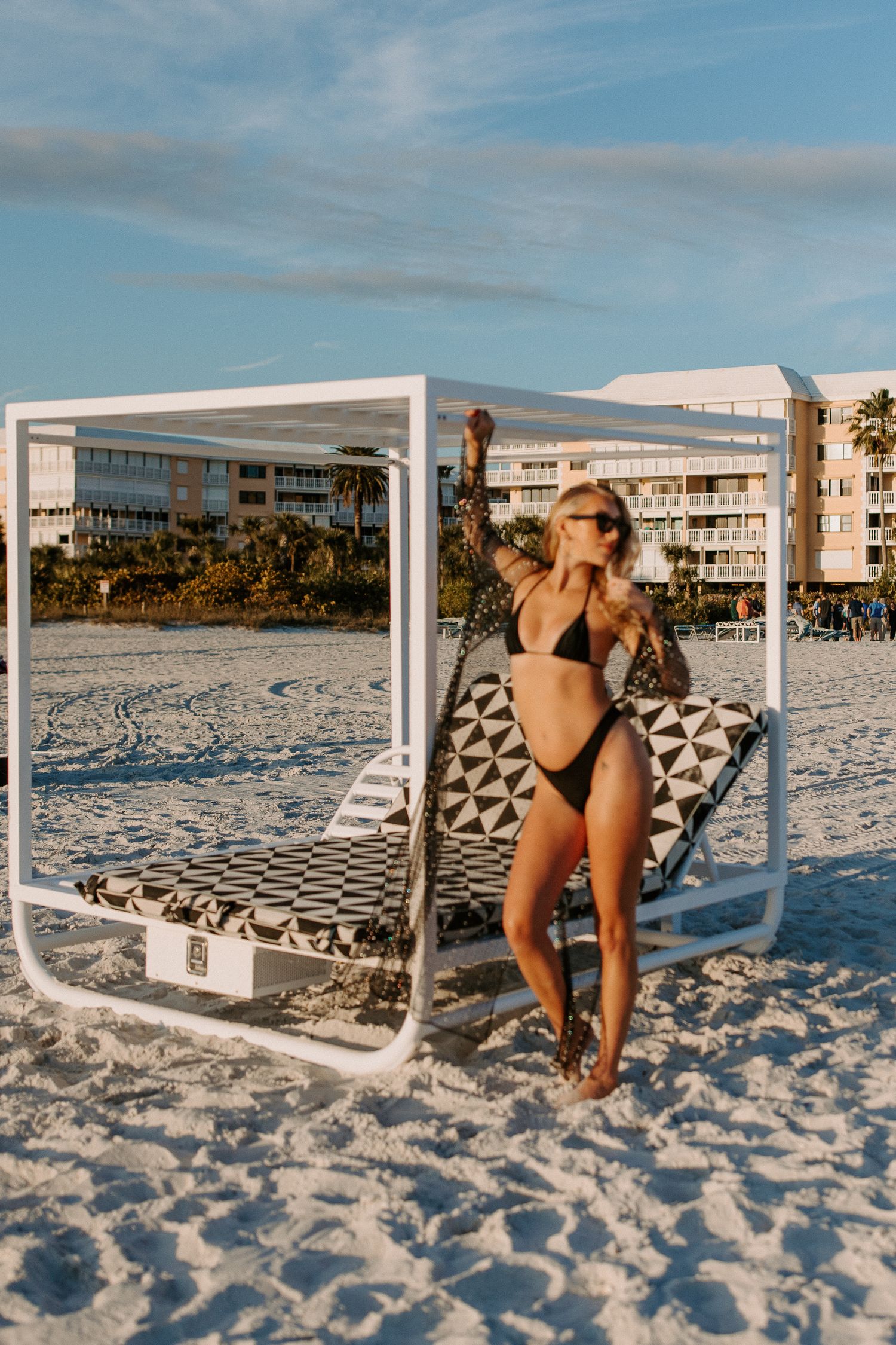Series of beach photos showing a white wooden frame structure on pristine white sand near the ocean.