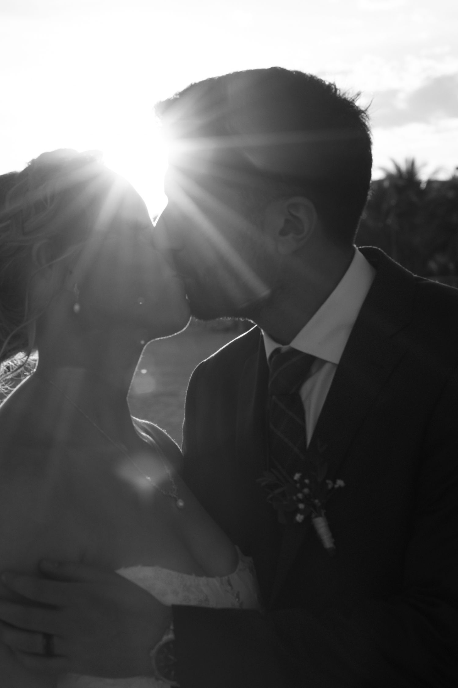 A romantic black and white silhouette sequence shows a couple kissing against bright sunlight in three progressive frames.