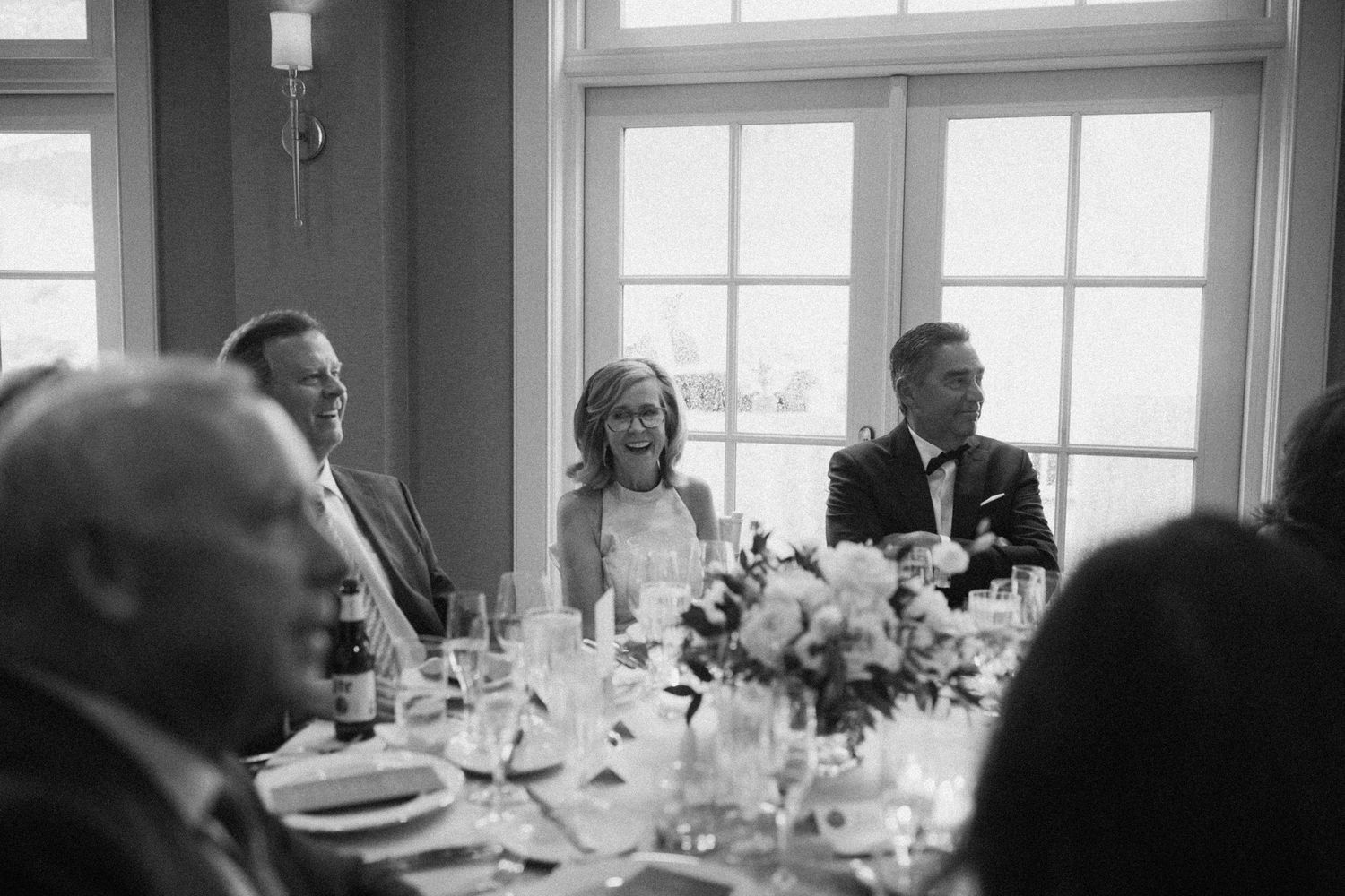 Panoramic view of an elegant wedding reception with natural light illuminating the dining area.