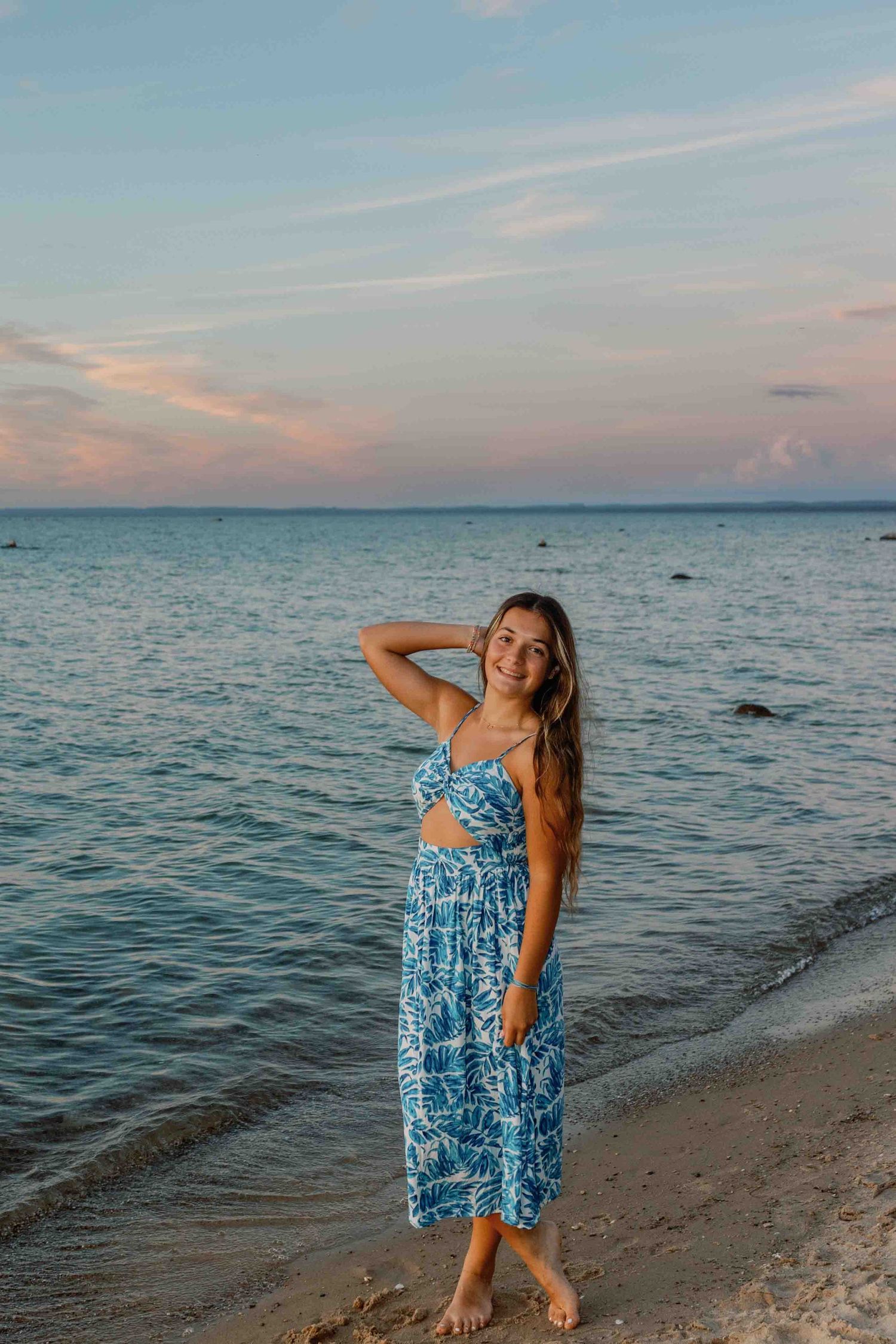 A carefree moment captured on the beach with someone twirling in a blue patterned summer dress.