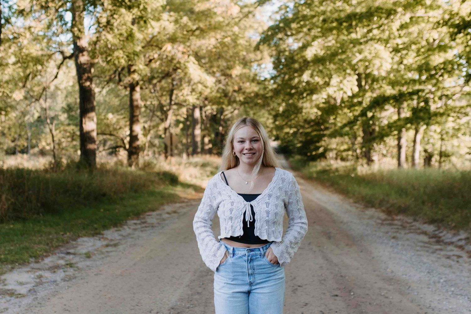 Outdoor fashion photography on a tree-lined path featuring cozy fall clothing.