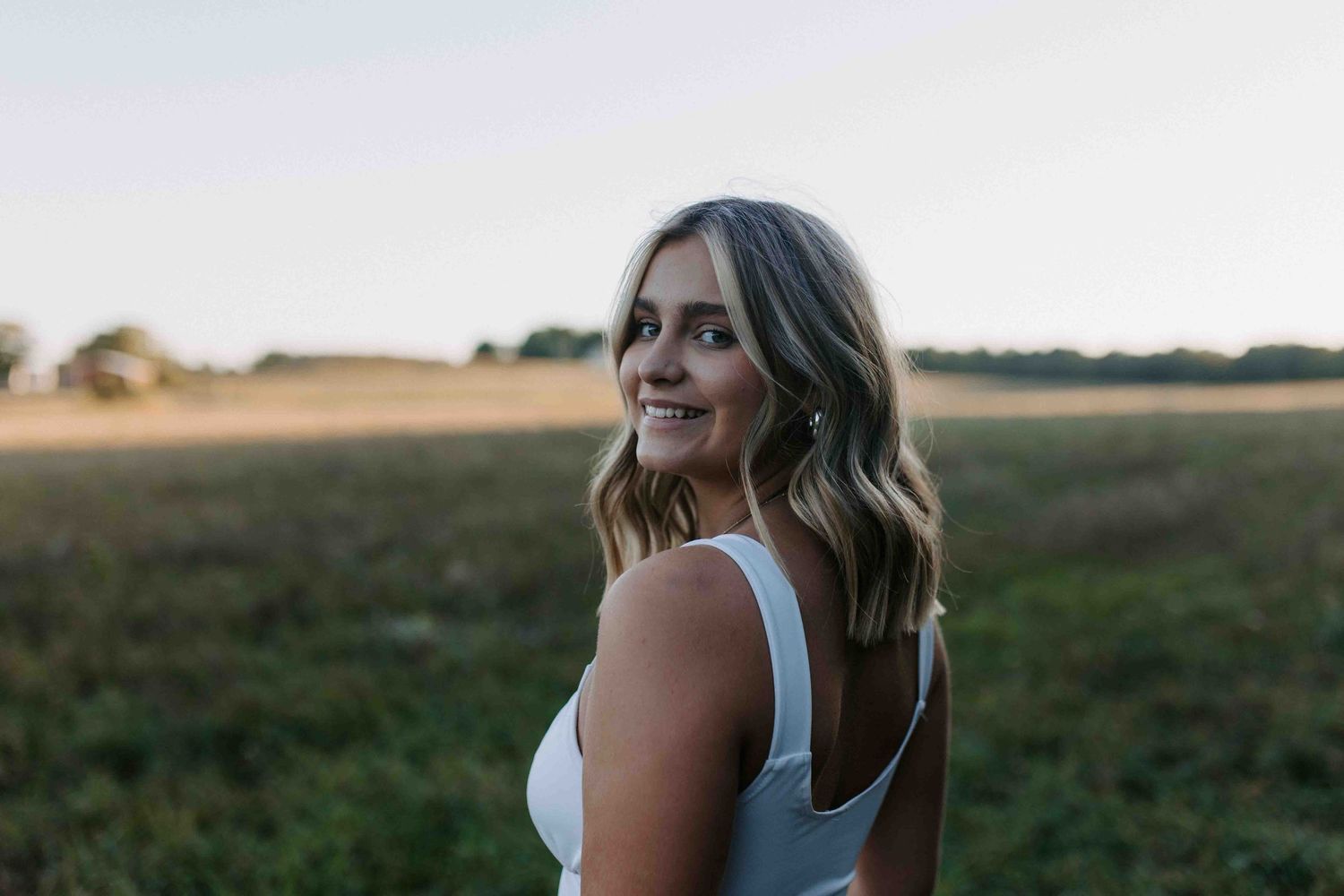 Summer evening photoshoot in a rural field with warm lighting.