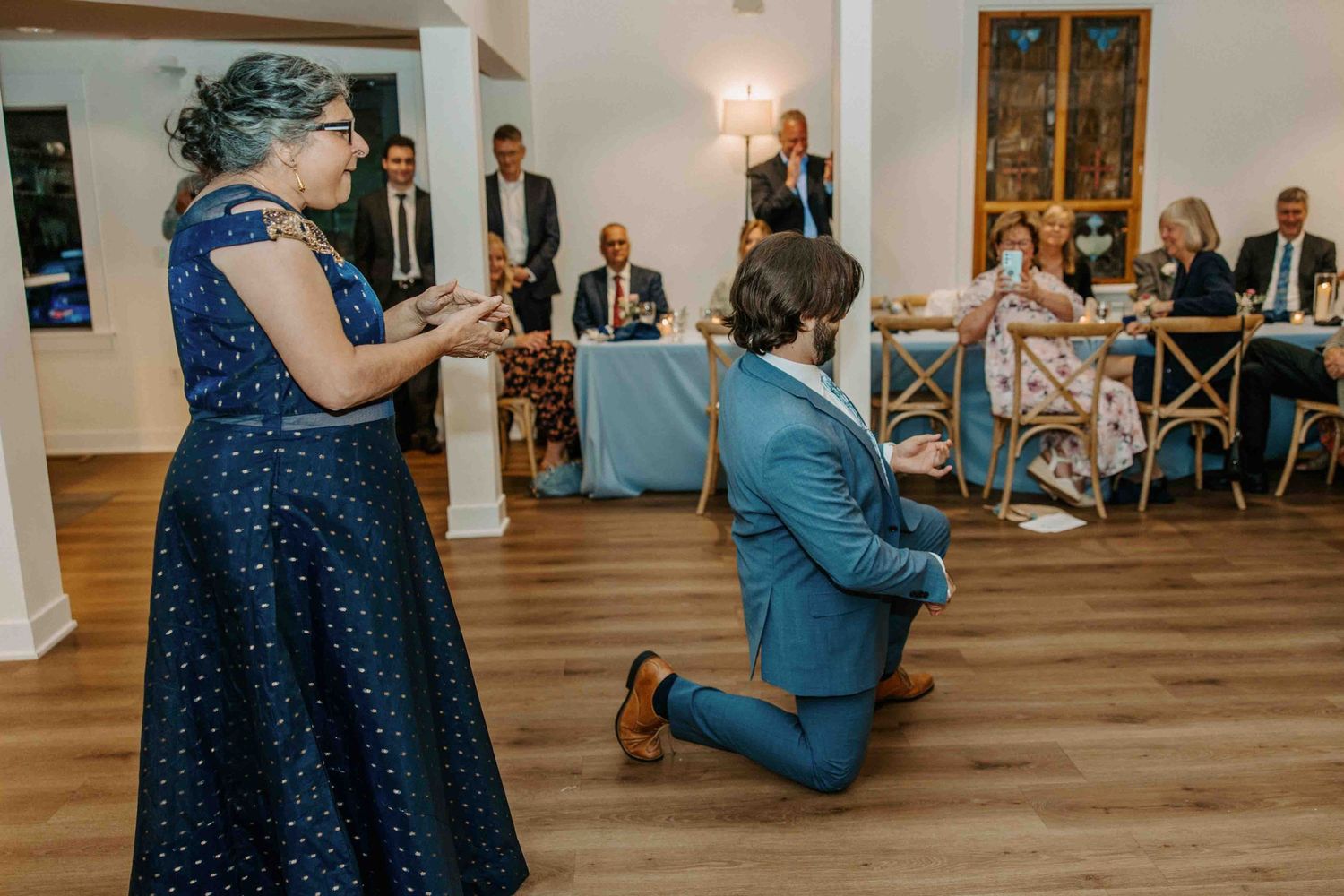 A special moment during a wedding reception as someone kneels on the dance floor.