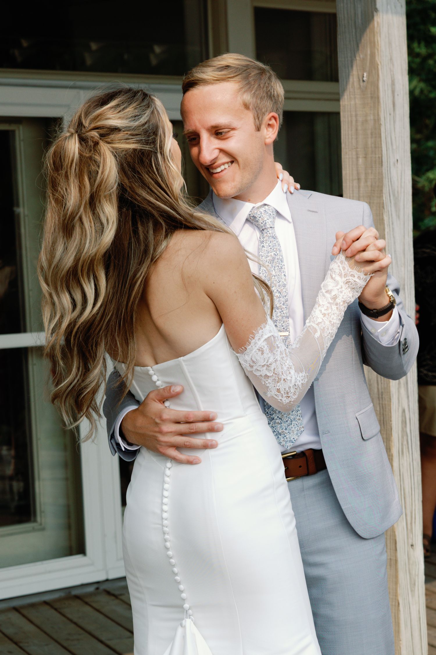 A close-up sequence showing details of a white wedding dress with buttons and lace.
