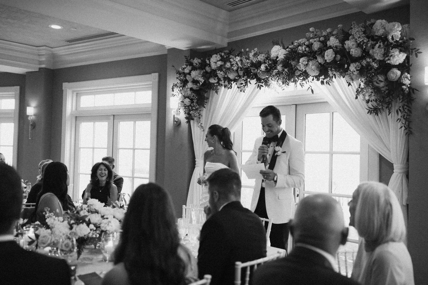 Wedding venue interior with classic crown molding and large windows.