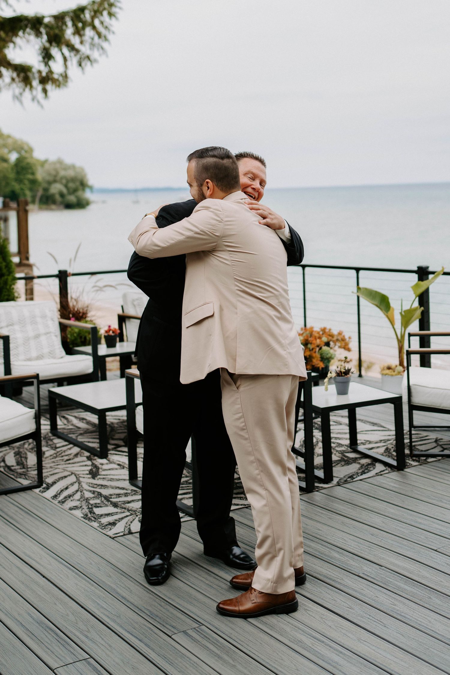 Emotional moment shared on a waterfront deck with scenic ocean views.