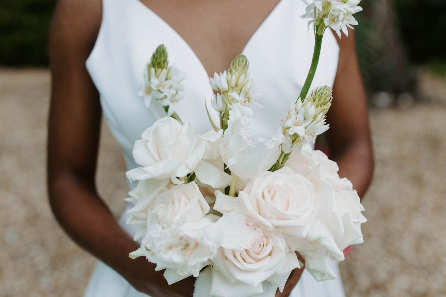 Close-up of an elegant white bridal bouquet with roses and delicate flowers.