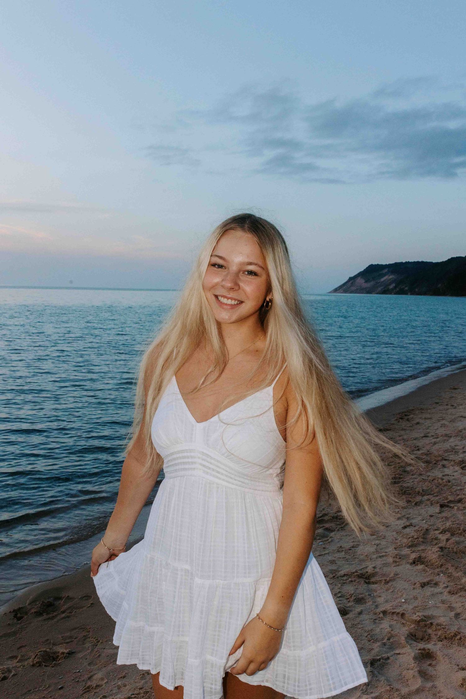 Beachside photo series showing someone in a white sundress against a scenic coastal backdrop.