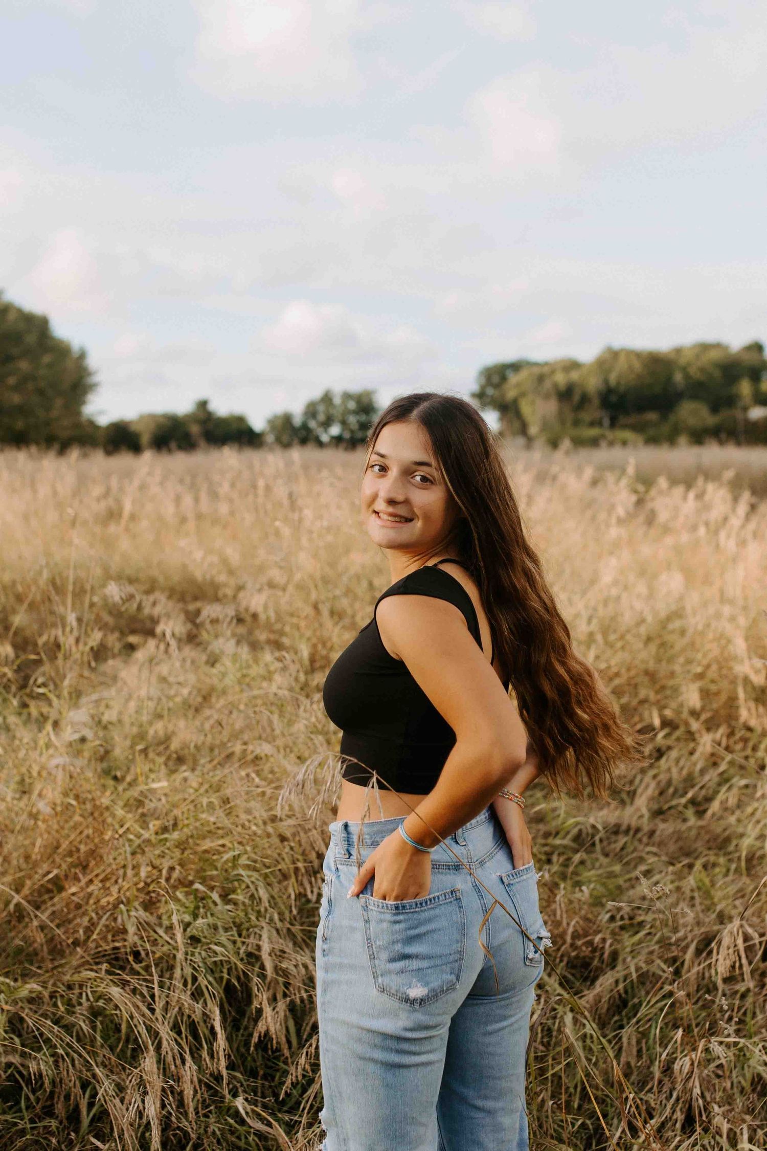 Portrait session in golden field with casual outfit and natural lighting.