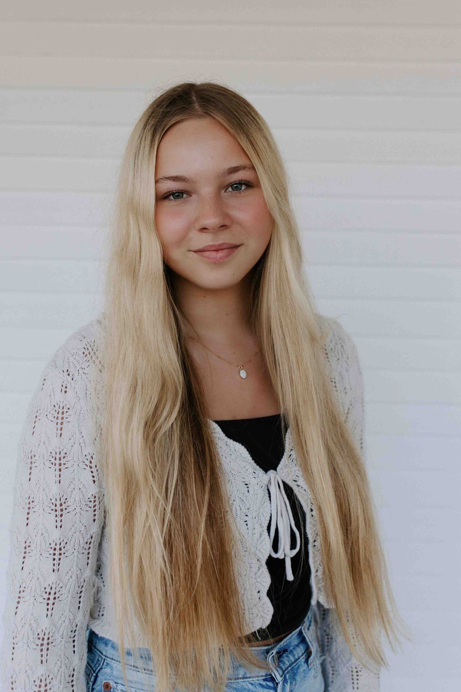 Portrait series showing casual style with white sweater and light denim.