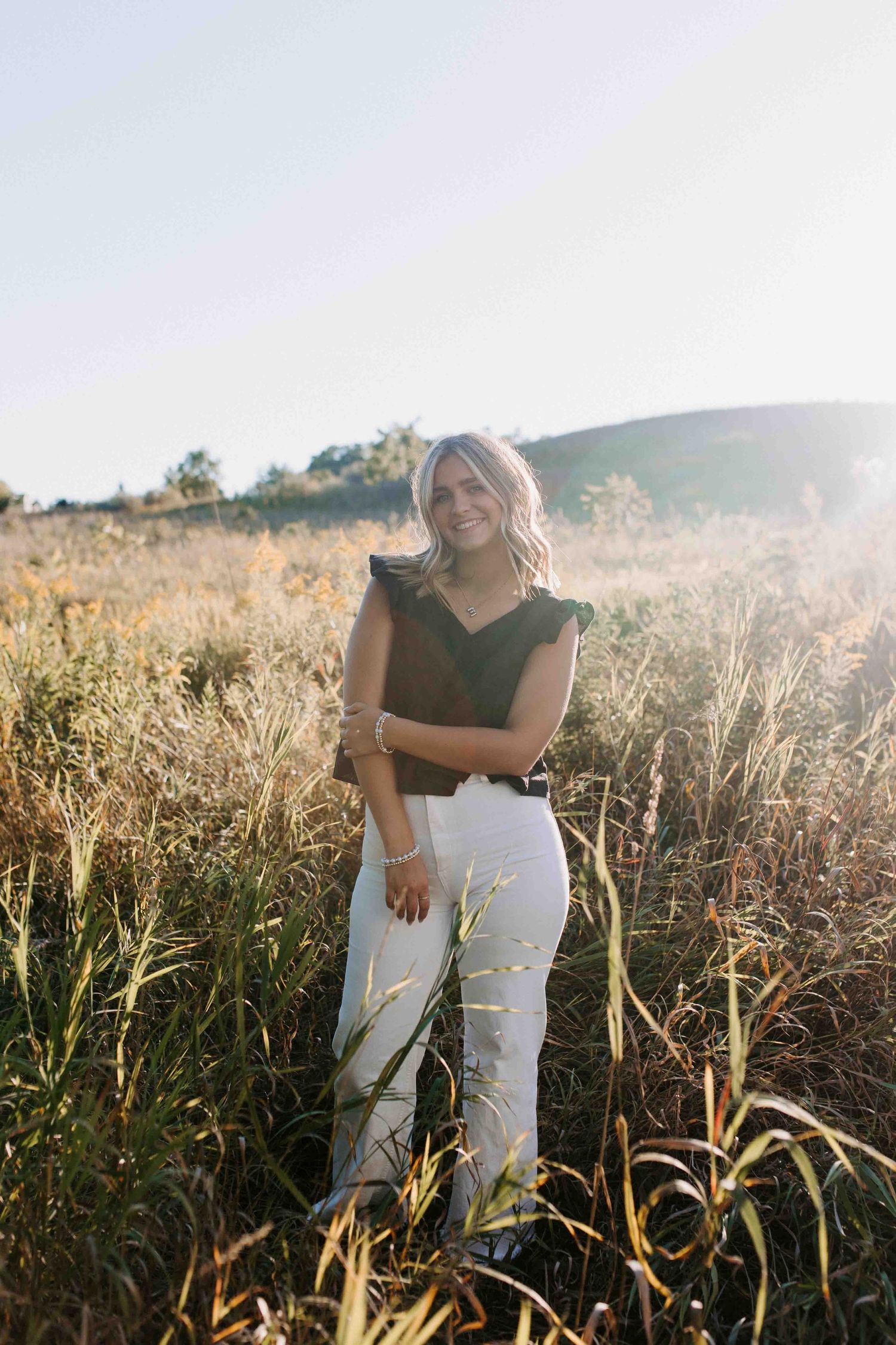 Candid outdoor shots in a sunlit field wearing black and white outfit.