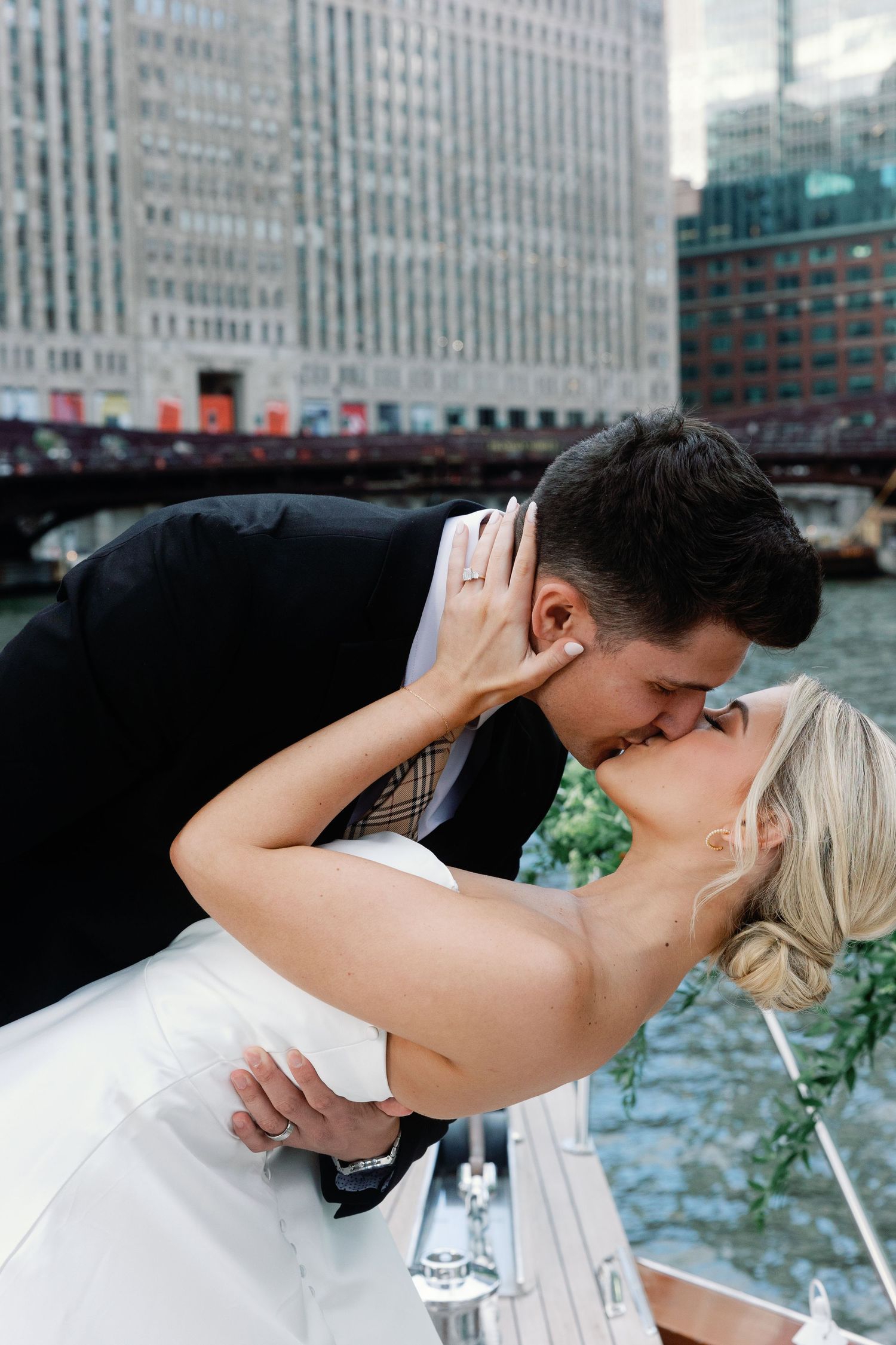 Intimate wedding moment captured on boat with Chicago architecture in background.