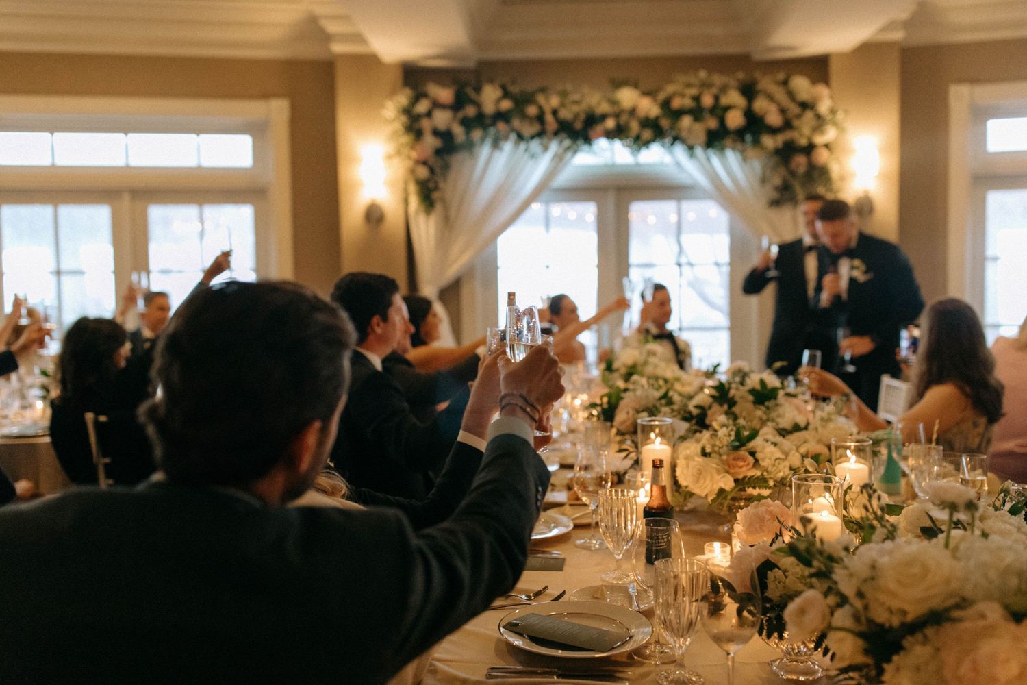 Elegant wedding reception space with floral centerpieces and warm ambient lighting.