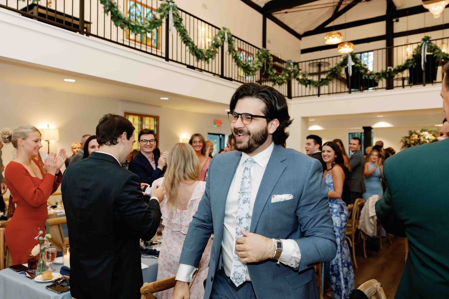 Wedding guests mingling and socializing during an indoor reception celebration.