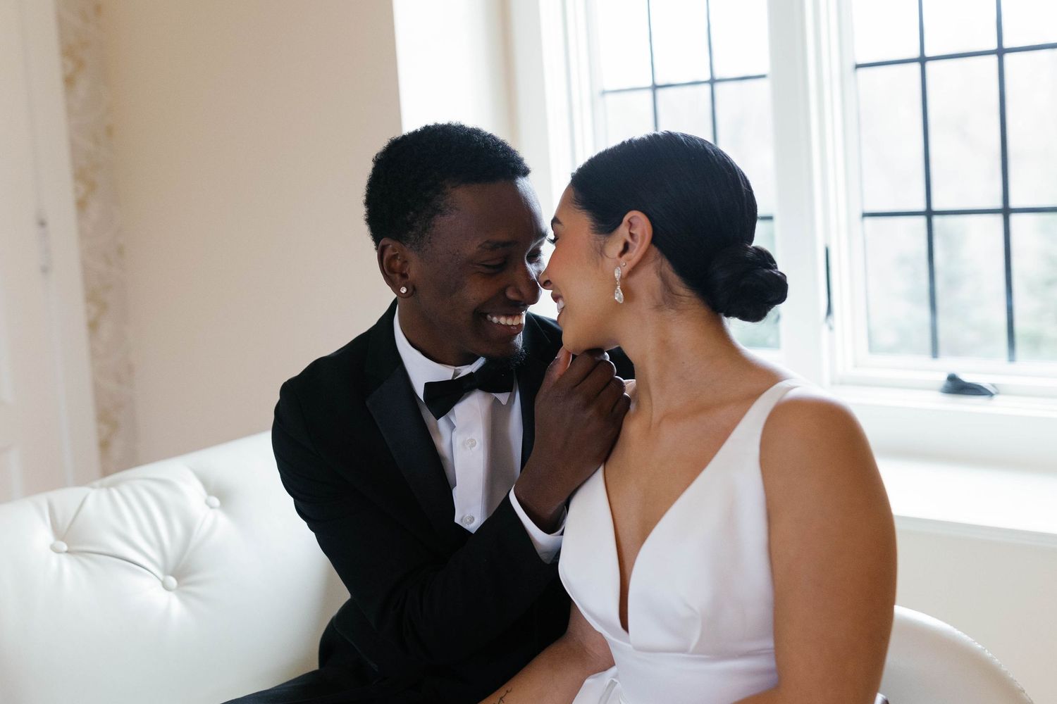 Intimate wedding couple portrait in front of bright windows.