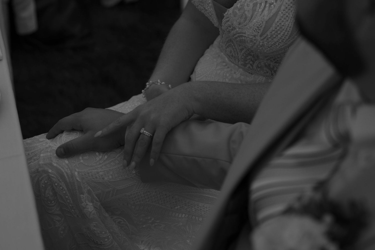 Black and white candid wedding photo capturing an intimate moment between the couple.