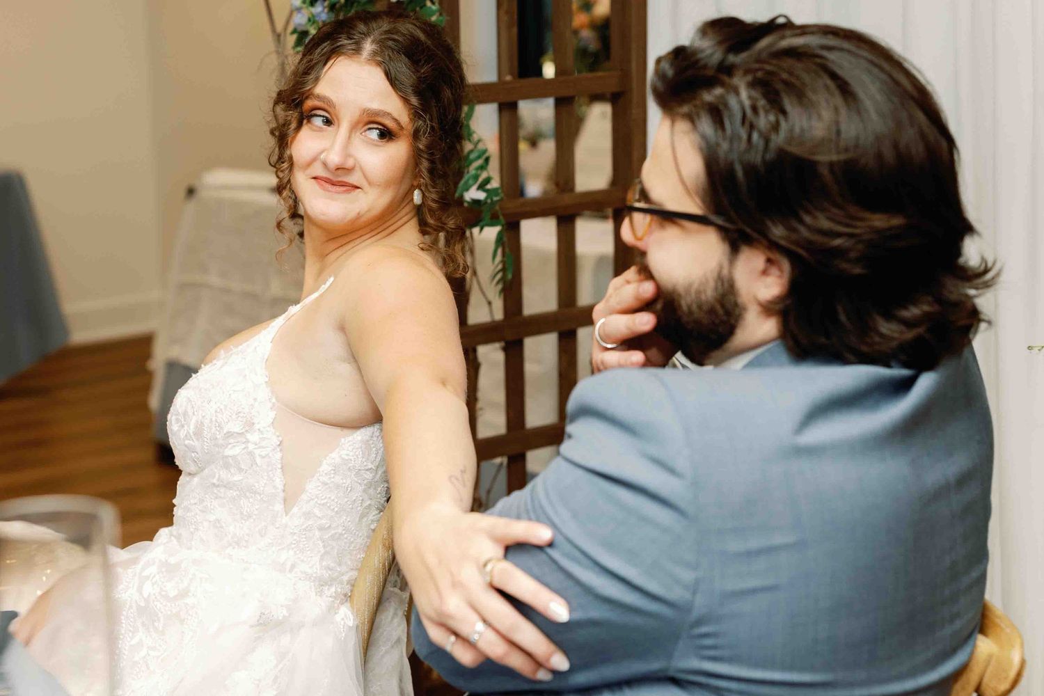 Emotional first look between couple in wedding attire at indoor venue.
