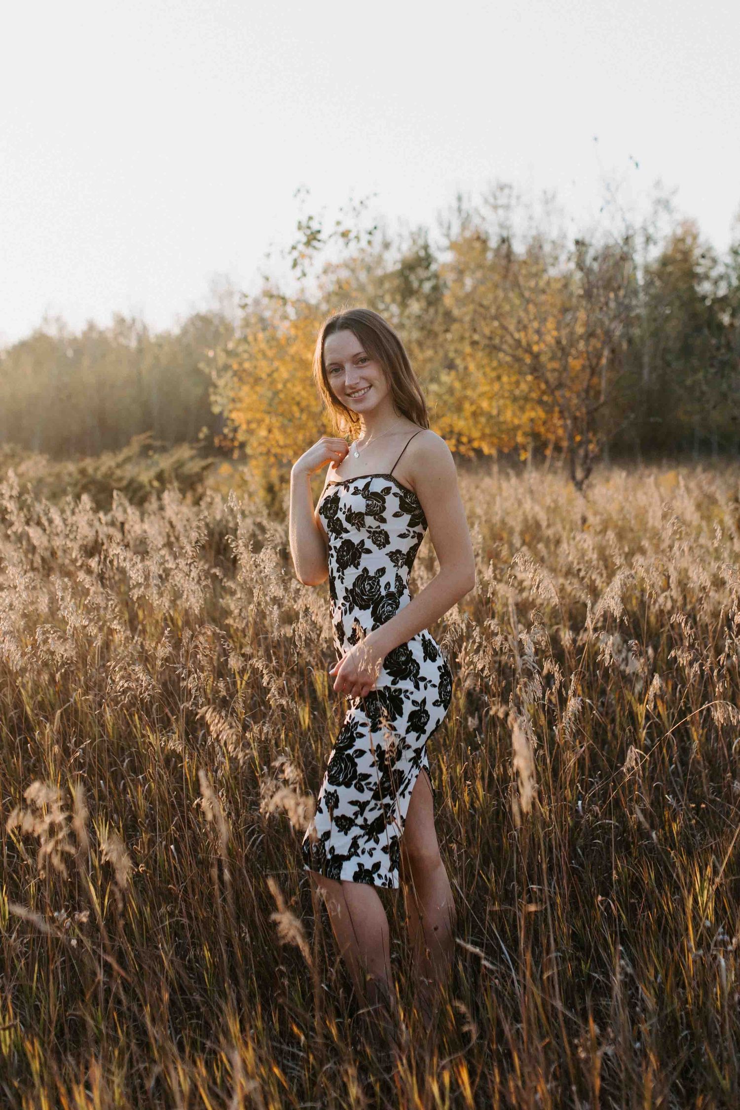 Summer portrait session in a field with golden light and tall grass.
