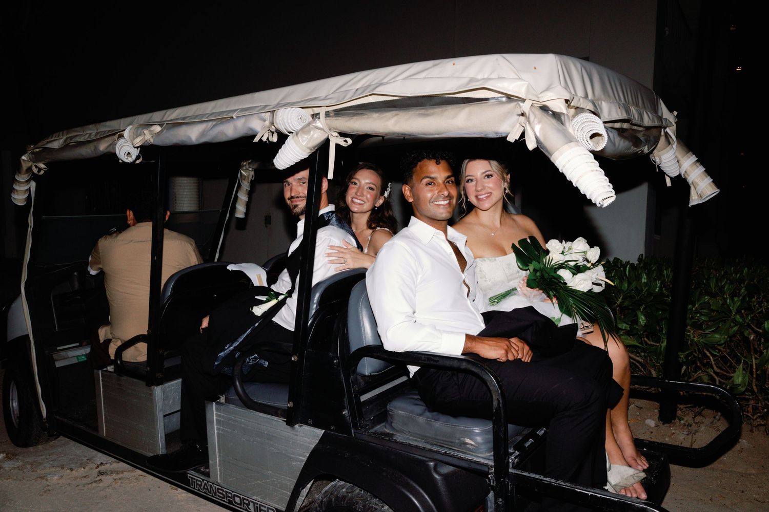 Wedding party members pose together in a limousine after the ceremony.