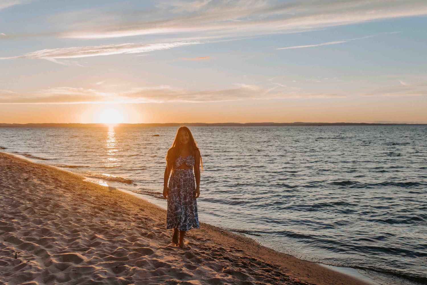 A scenic beach sunset with golden light reflecting off the ocean waves.