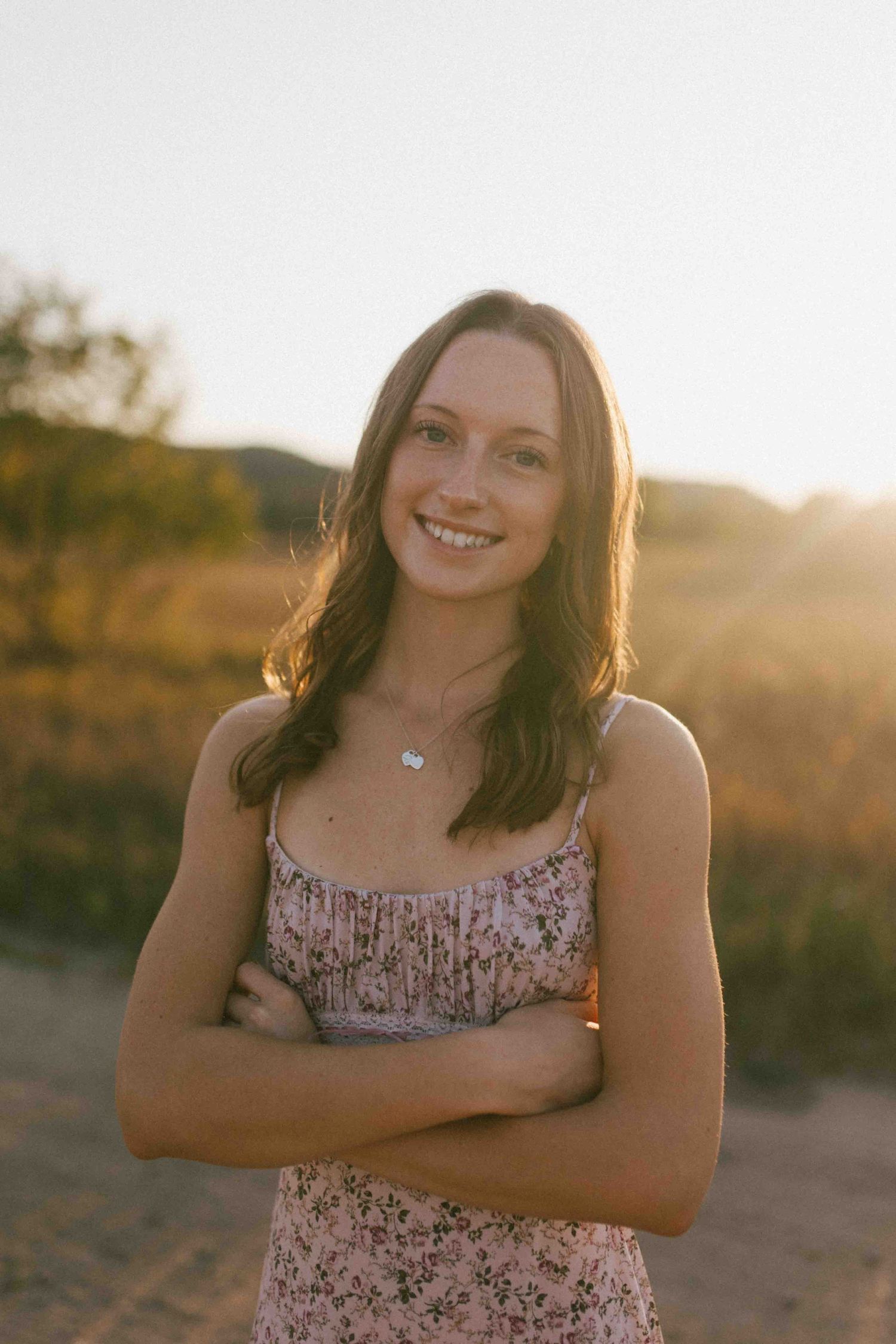 A candid sunset portrait shows someone smiling warmly in golden evening light.