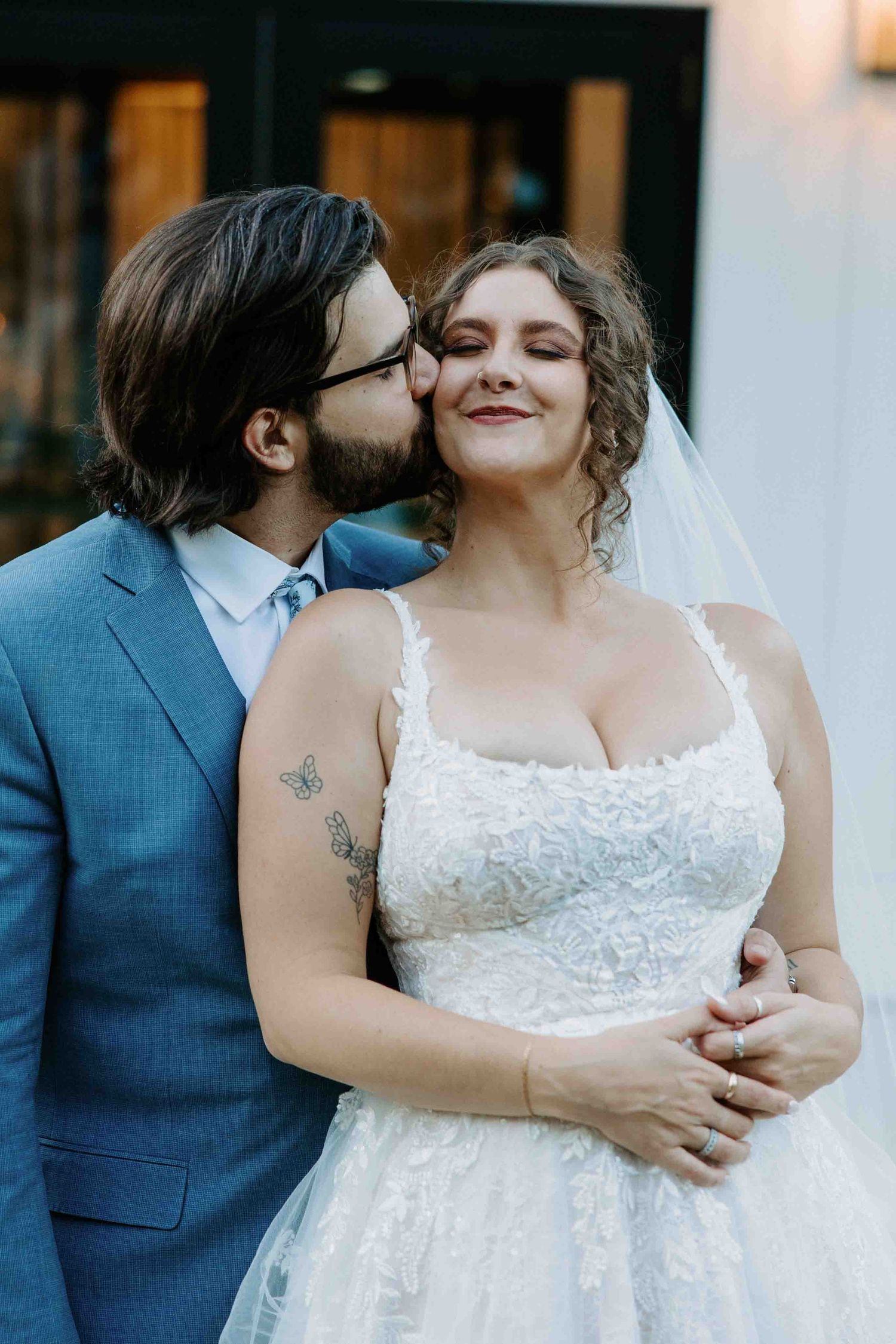 Romantic wedding portrait showing tender moments in white dress and blue suit.