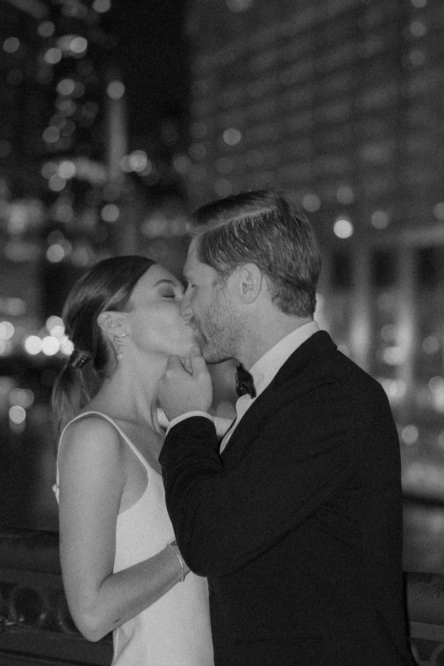 A romantic black and white nighttime portrait of a couple sharing an intimate moment.