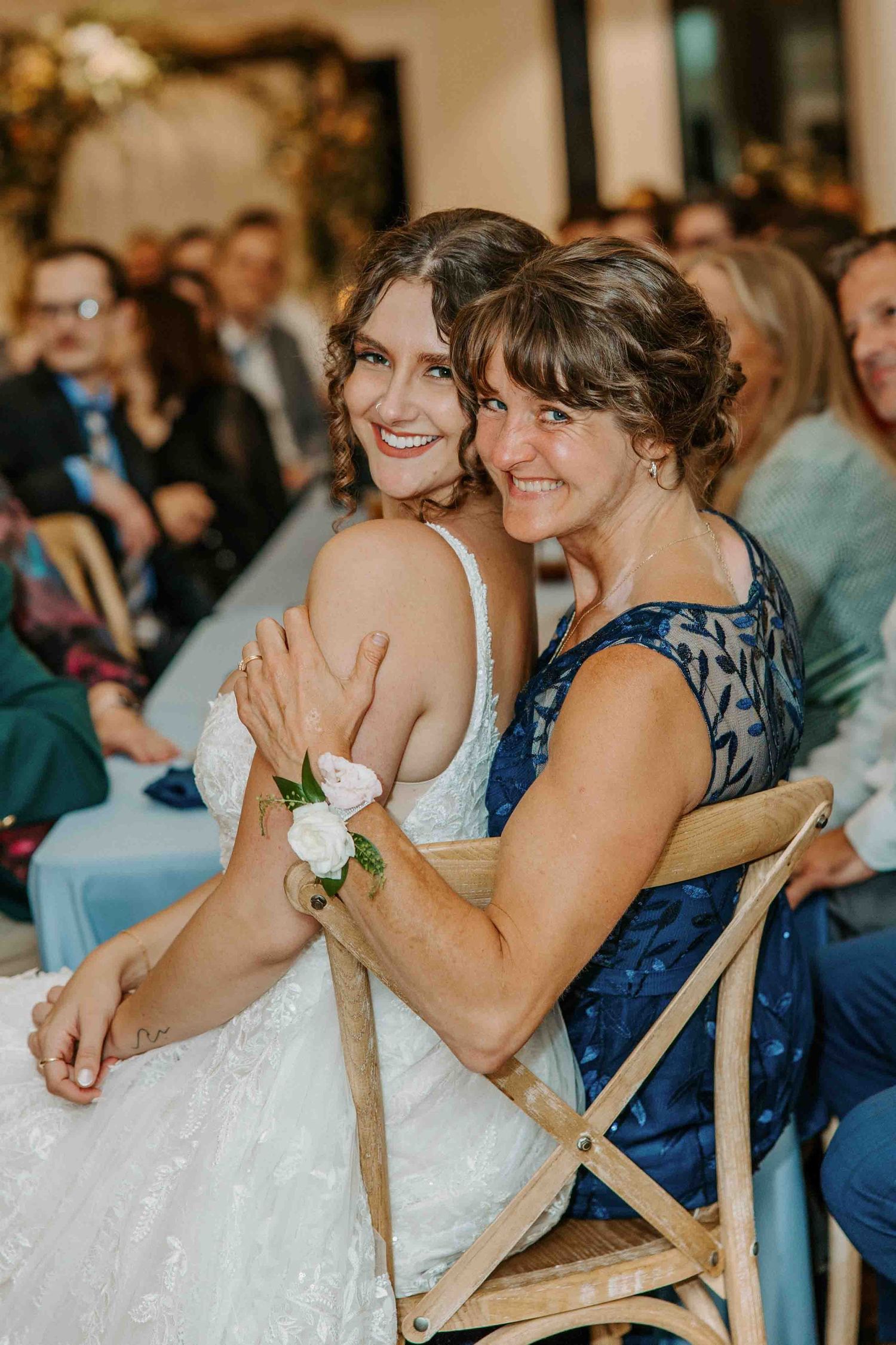 Wedding party members in navy dresses share emotional moments during reception celebrations.