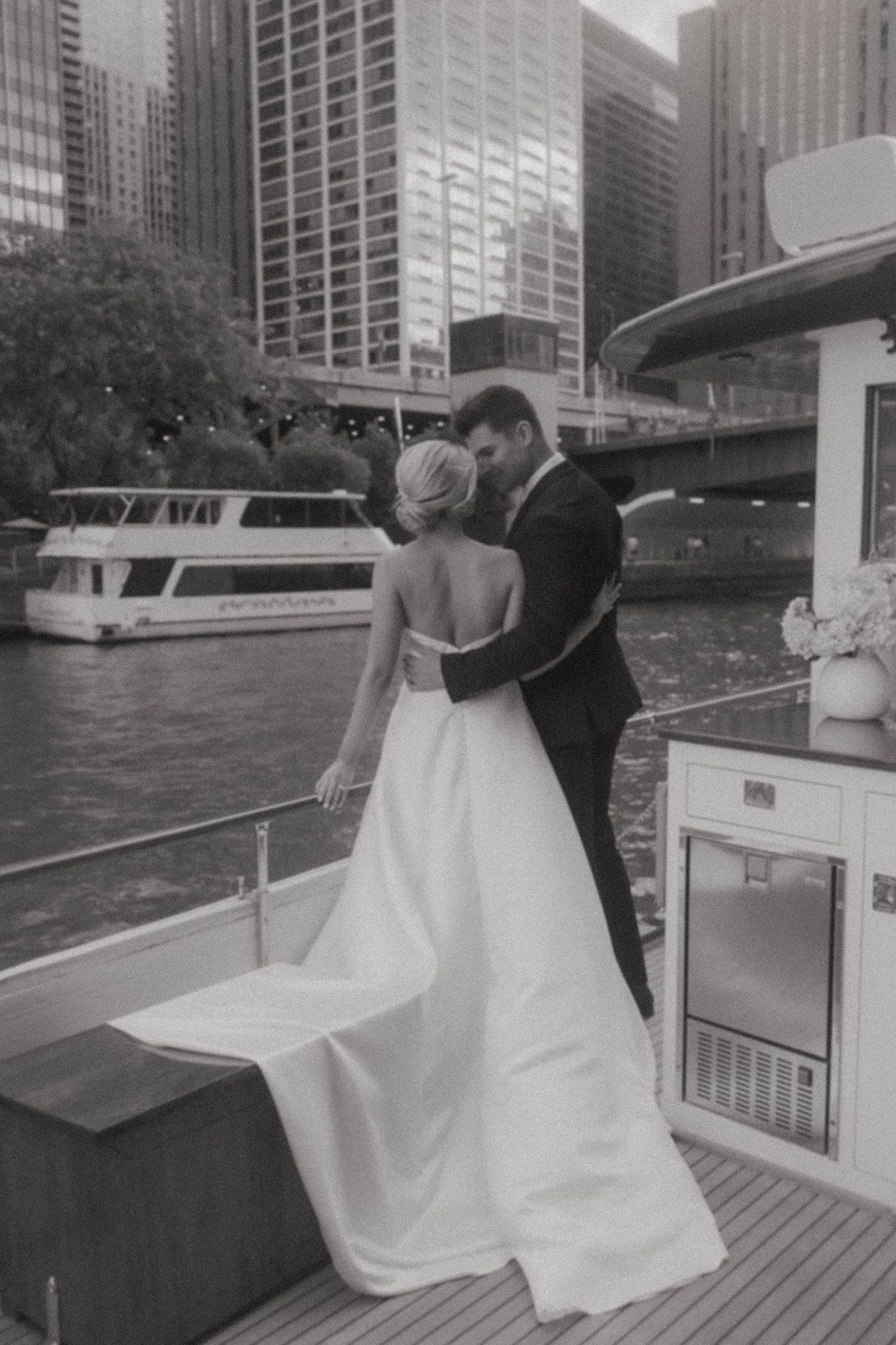 Black and white wedding photo on boat deck with Chicago skyline visible.