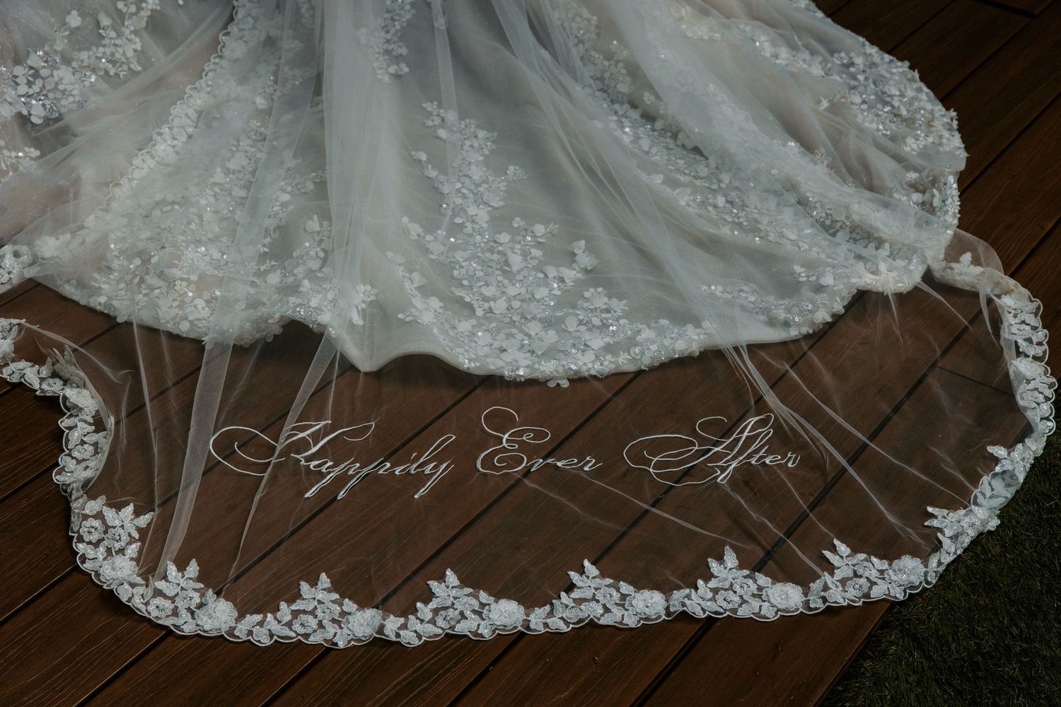 Close-up details of intricate lace patterns on a white wedding dress train.