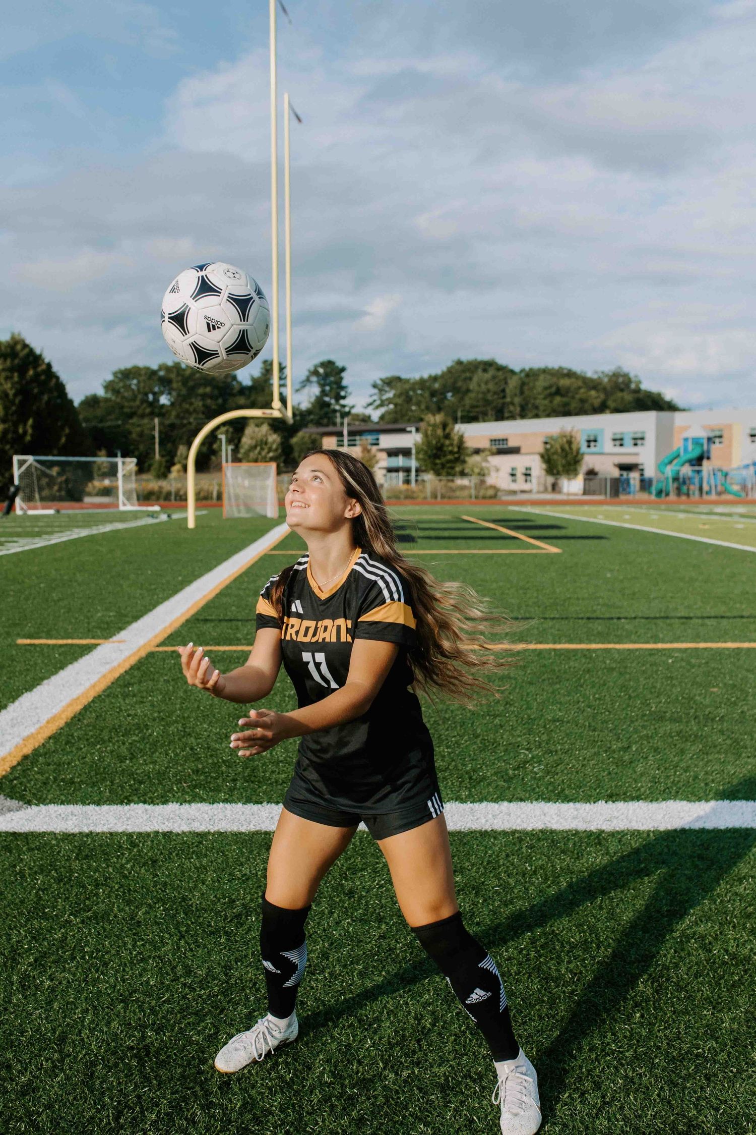 Soccer player demonstrating juggling skills on green turf field.