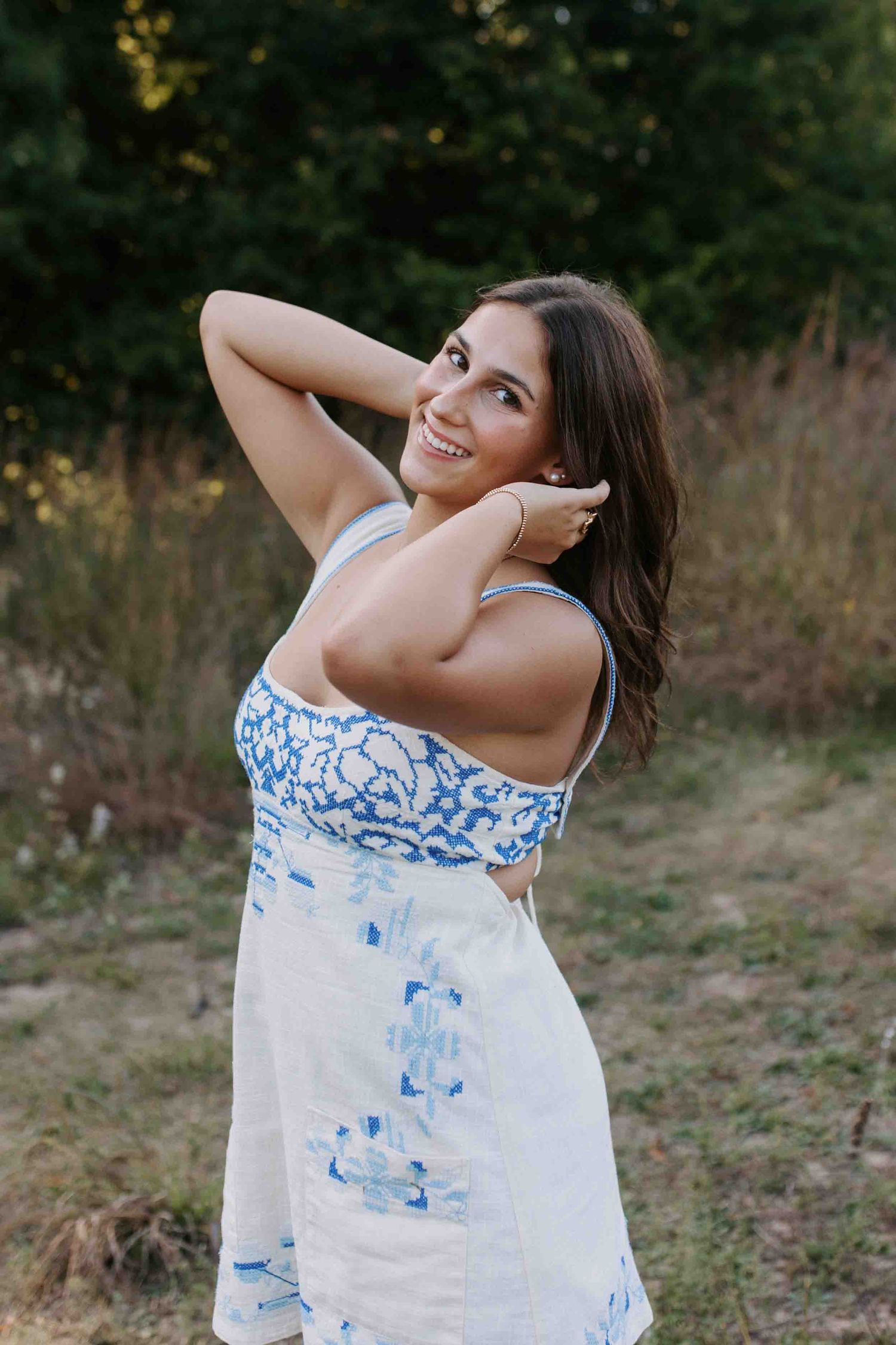 Candid outdoor photoshoot featuring a white summer dress with blue tie-dye pattern.