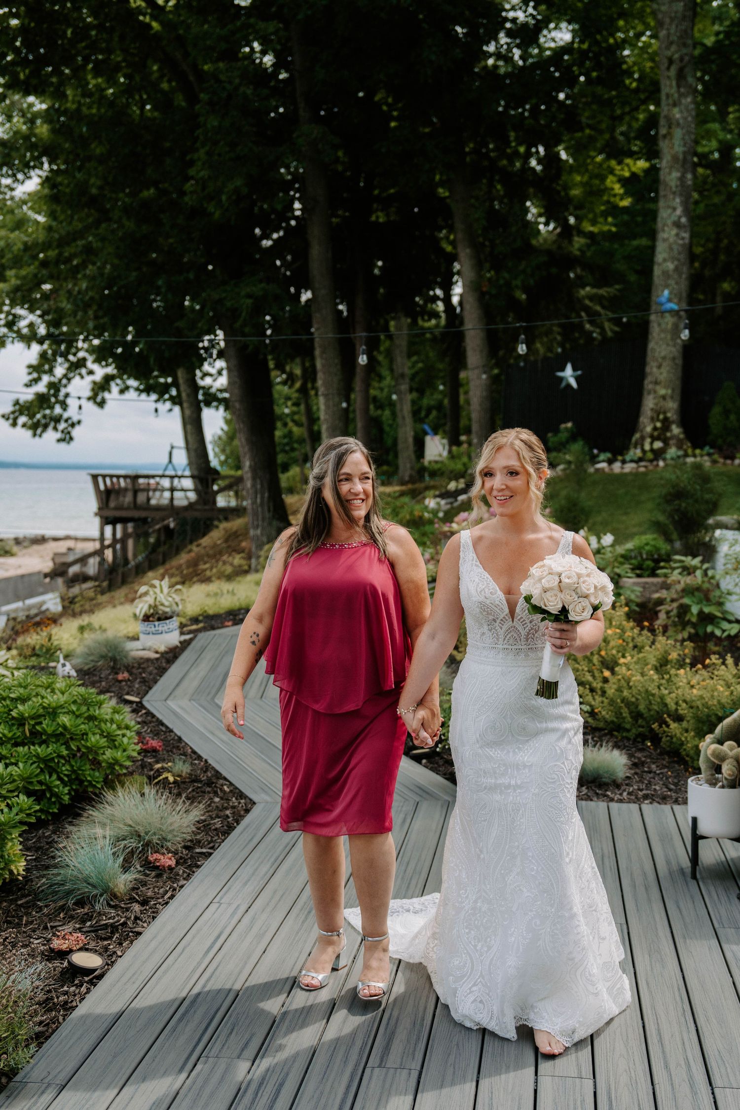 Wedding party walking along wooden boardwalk with water views.