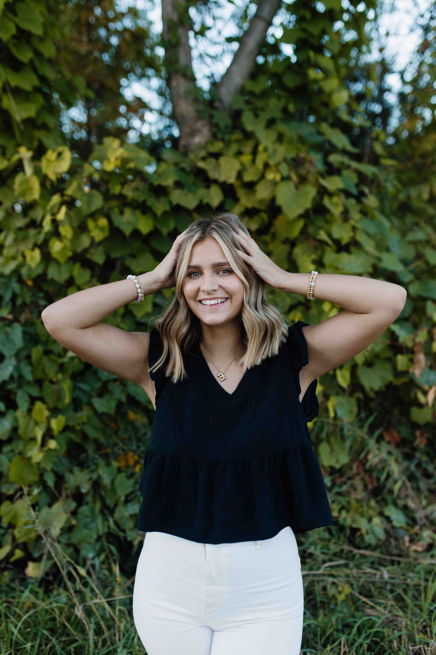Playful outdoor photoshoot with greenery backdrop showing casual summer style and natural expressions.