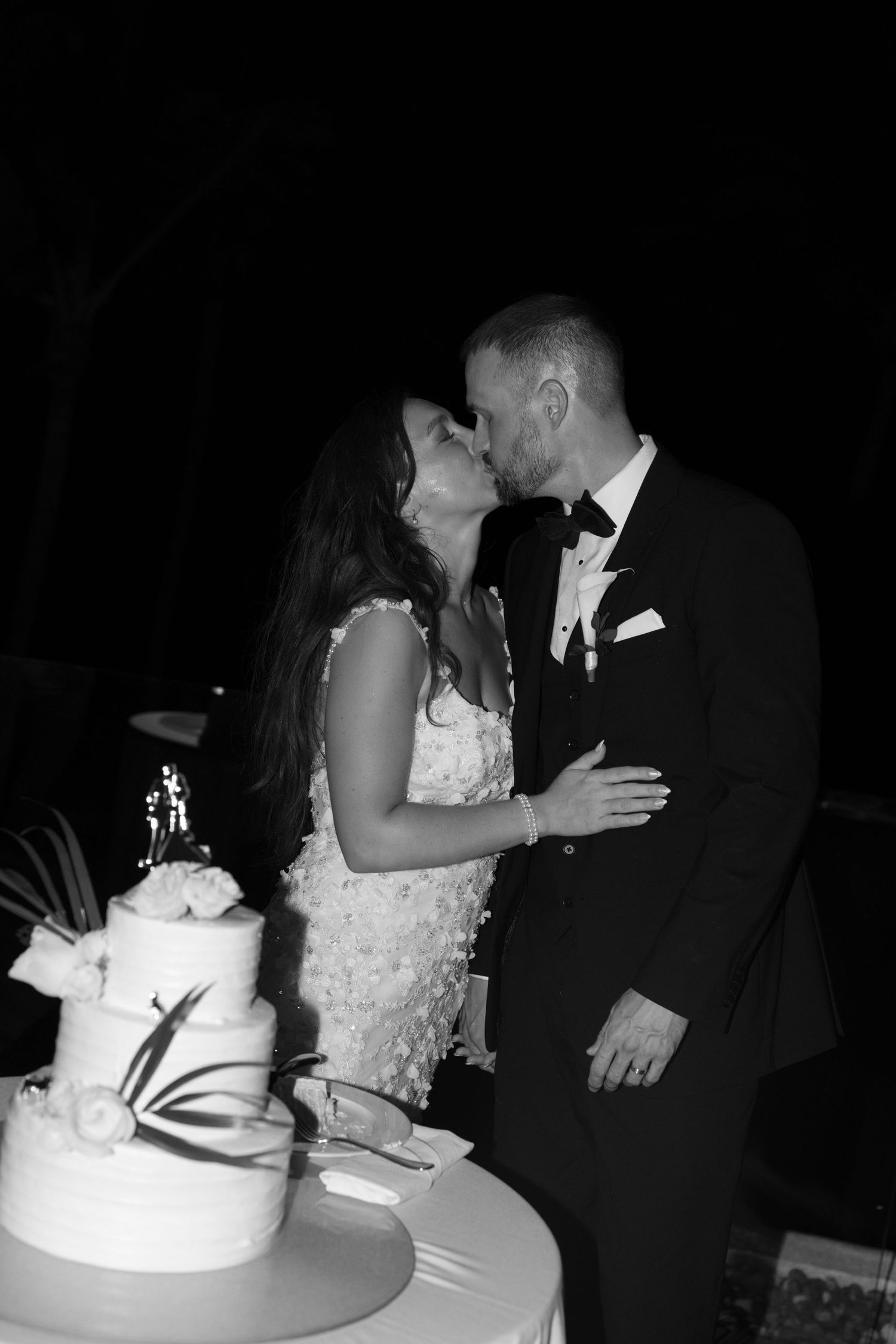Newlyweds cut their elegant white wedding cake together during the reception.