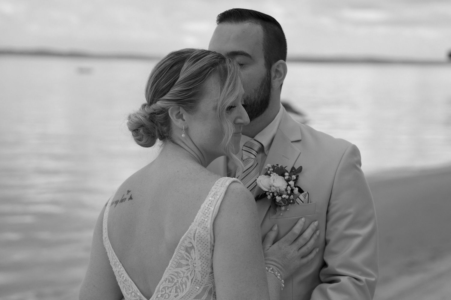 Black and white beach wedding photos showing tender moments between newlyweds.