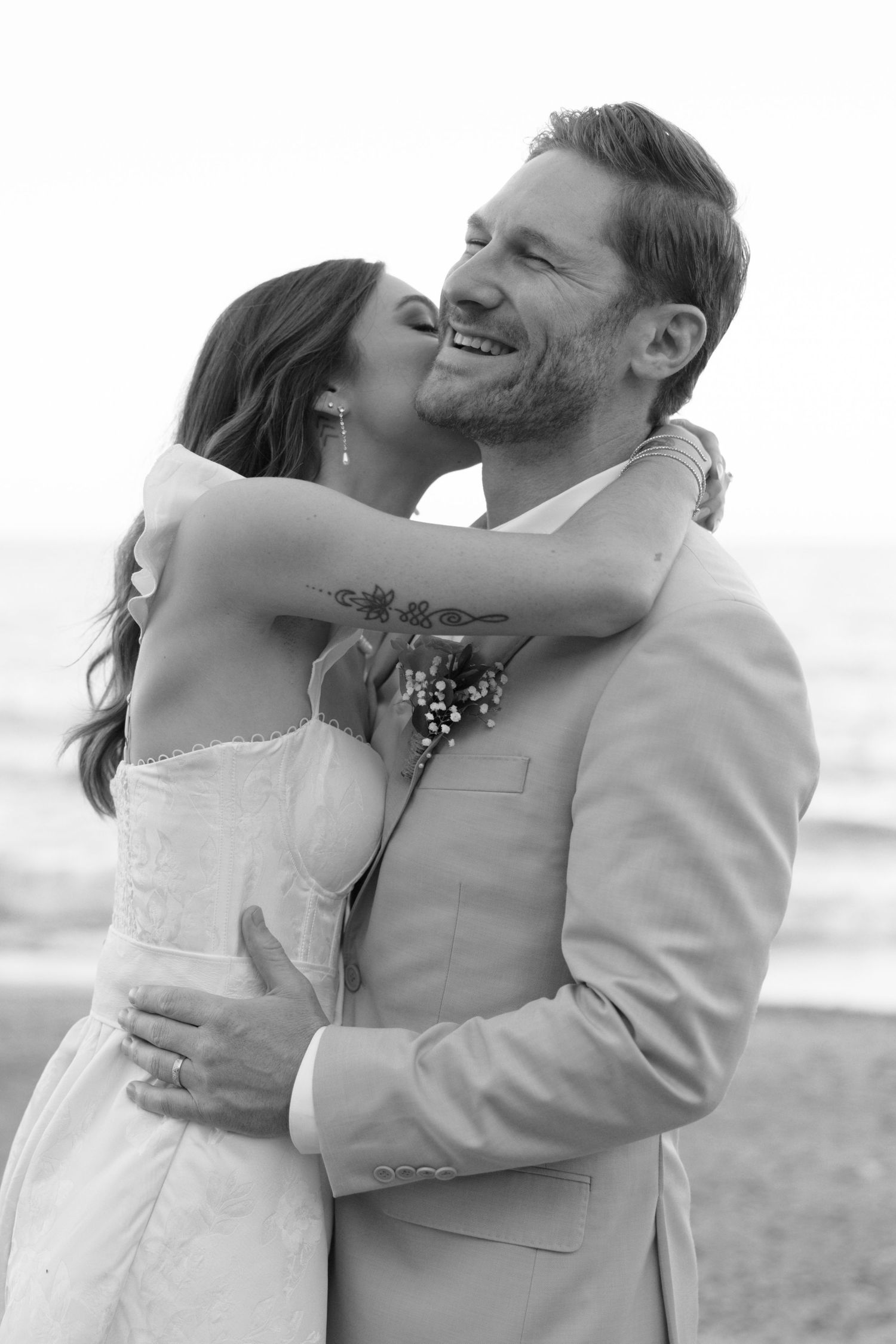 Candid wedding photos capturing joyful laughter and embraces on a beach.