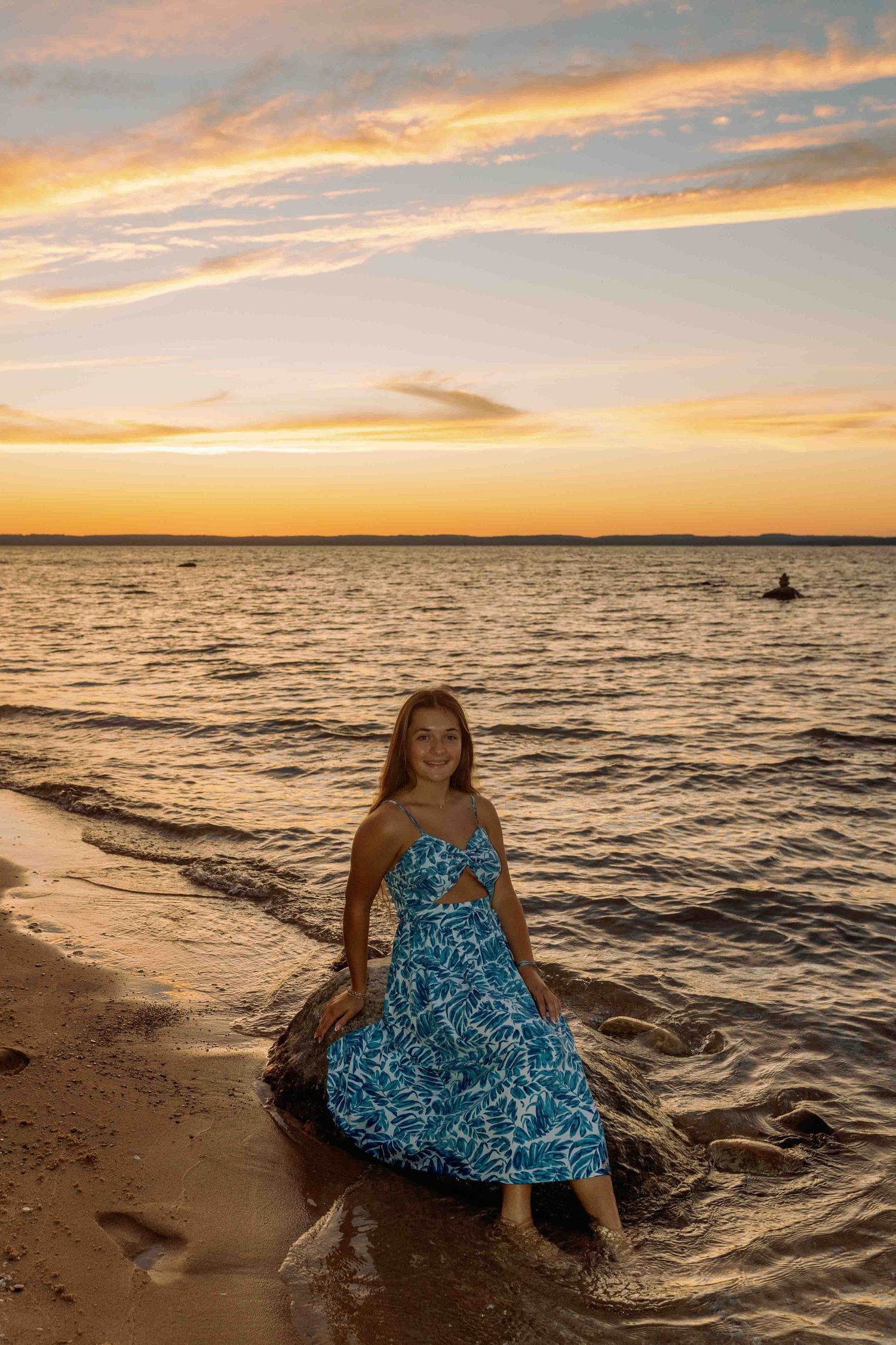 Sunset photoshoot on a beach with waves and golden sky in the background.