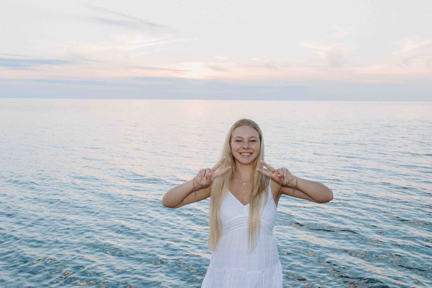 Playful poses captured against a serene ocean backdrop at sunset.
