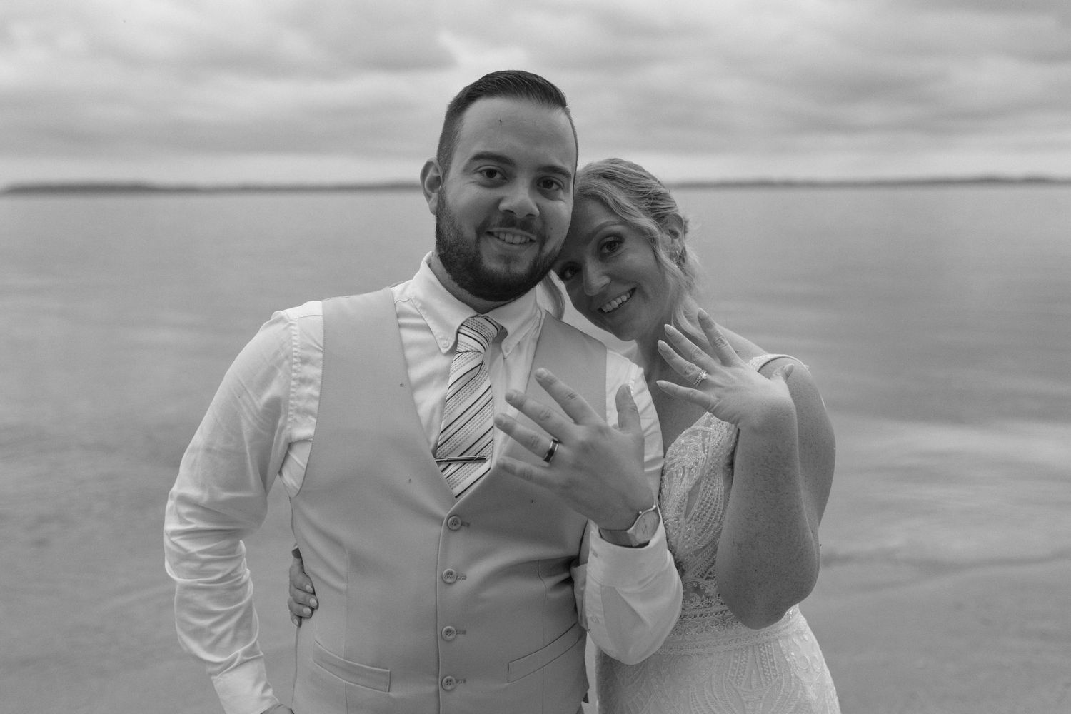 Black and white portraits of a wedding couple sharing intimate moments on the beach.