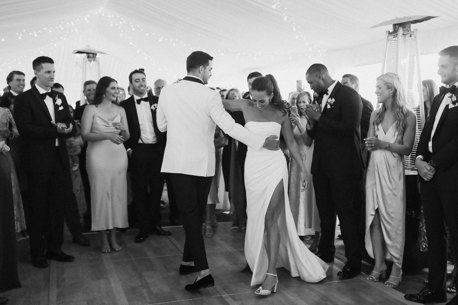 Wedding guests dancing and mingling at an indoor reception with natural light streaming in.