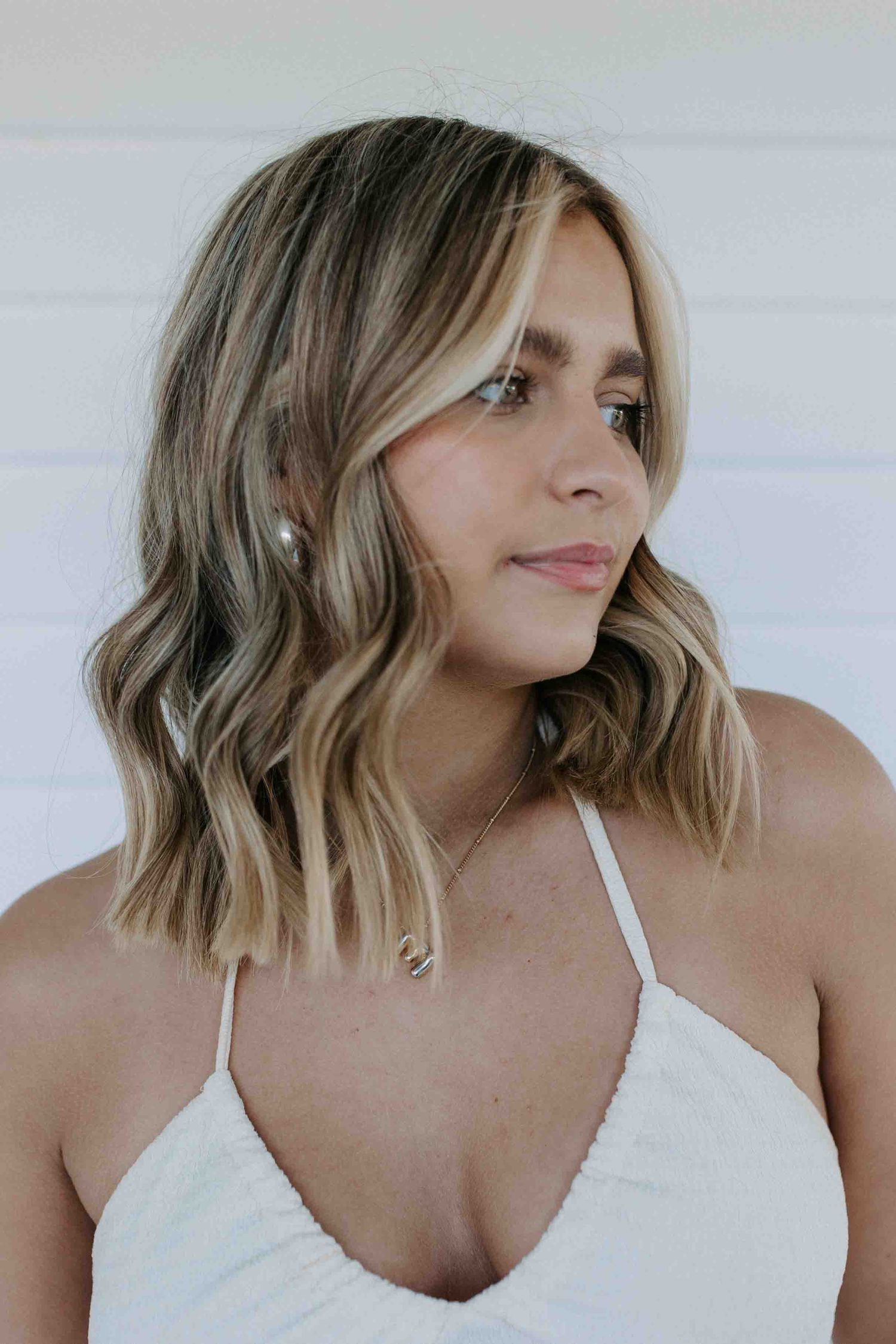Close-up profile shots showing wavy blonde hair and white camisole.