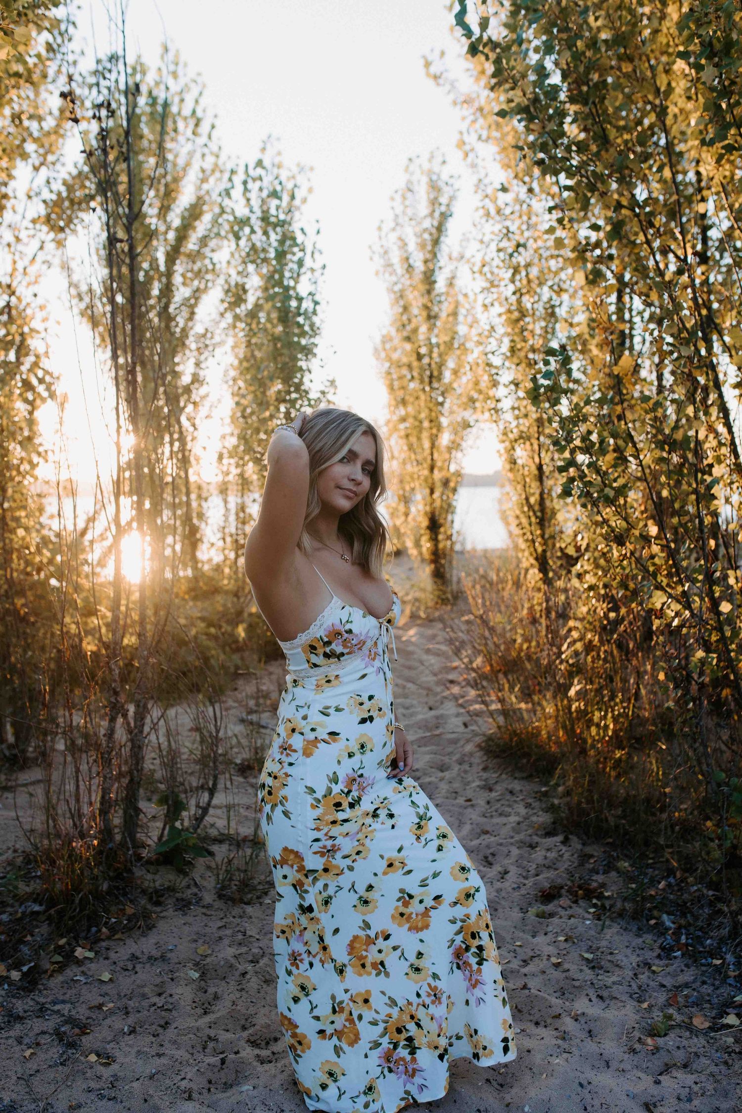 A dreamy outdoor portrait session at golden hour with warm sunlight and natural scenery.