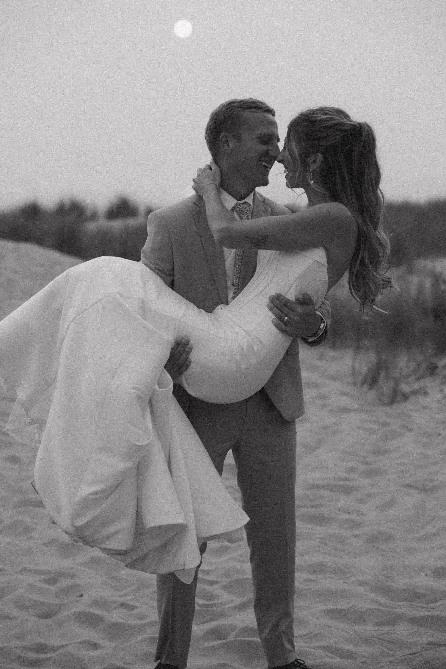 Black and white beach wedding portraits capture romantic moments between newlyweds.