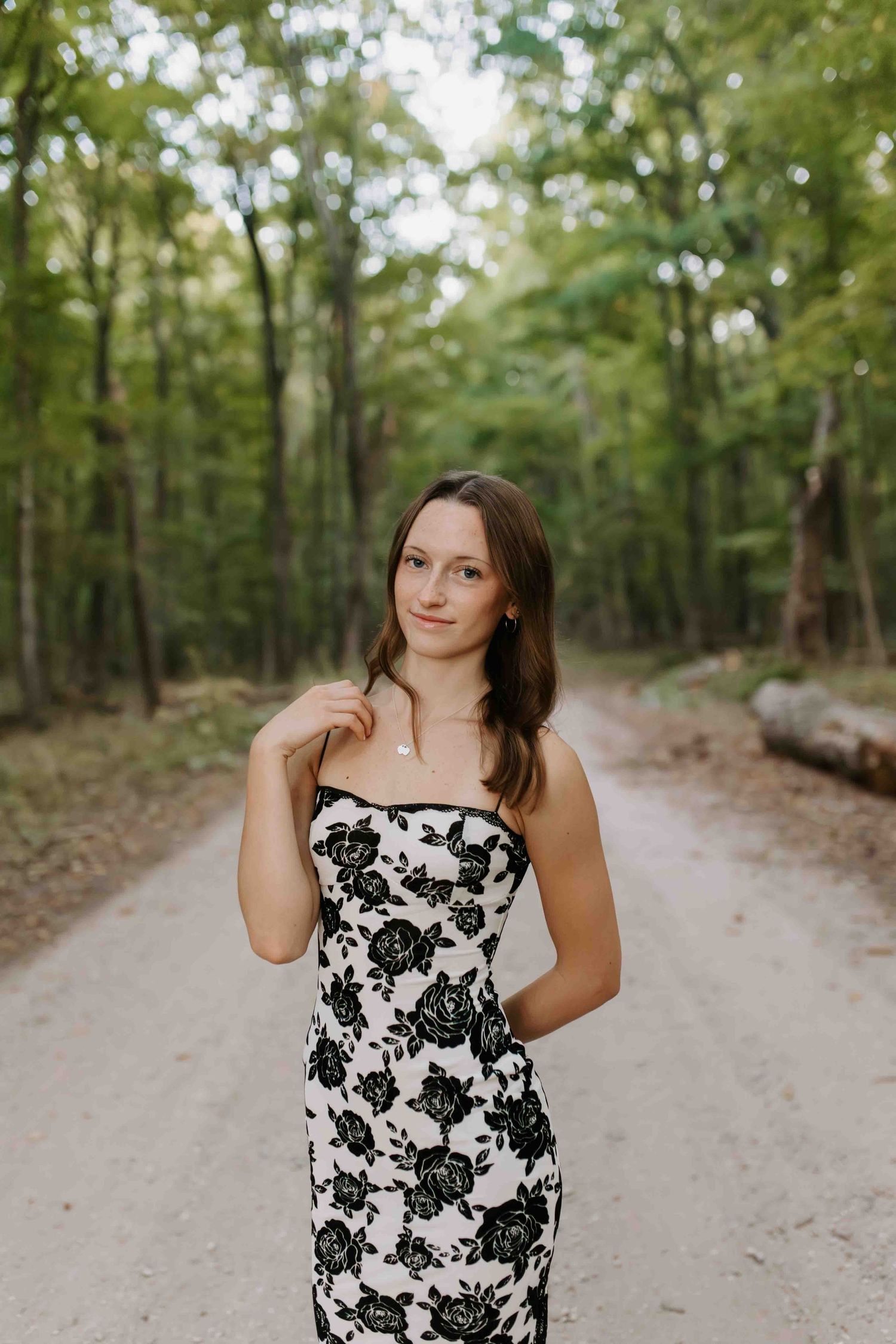 Strapless floral dress captured on a winding dirt path through a wooded area.